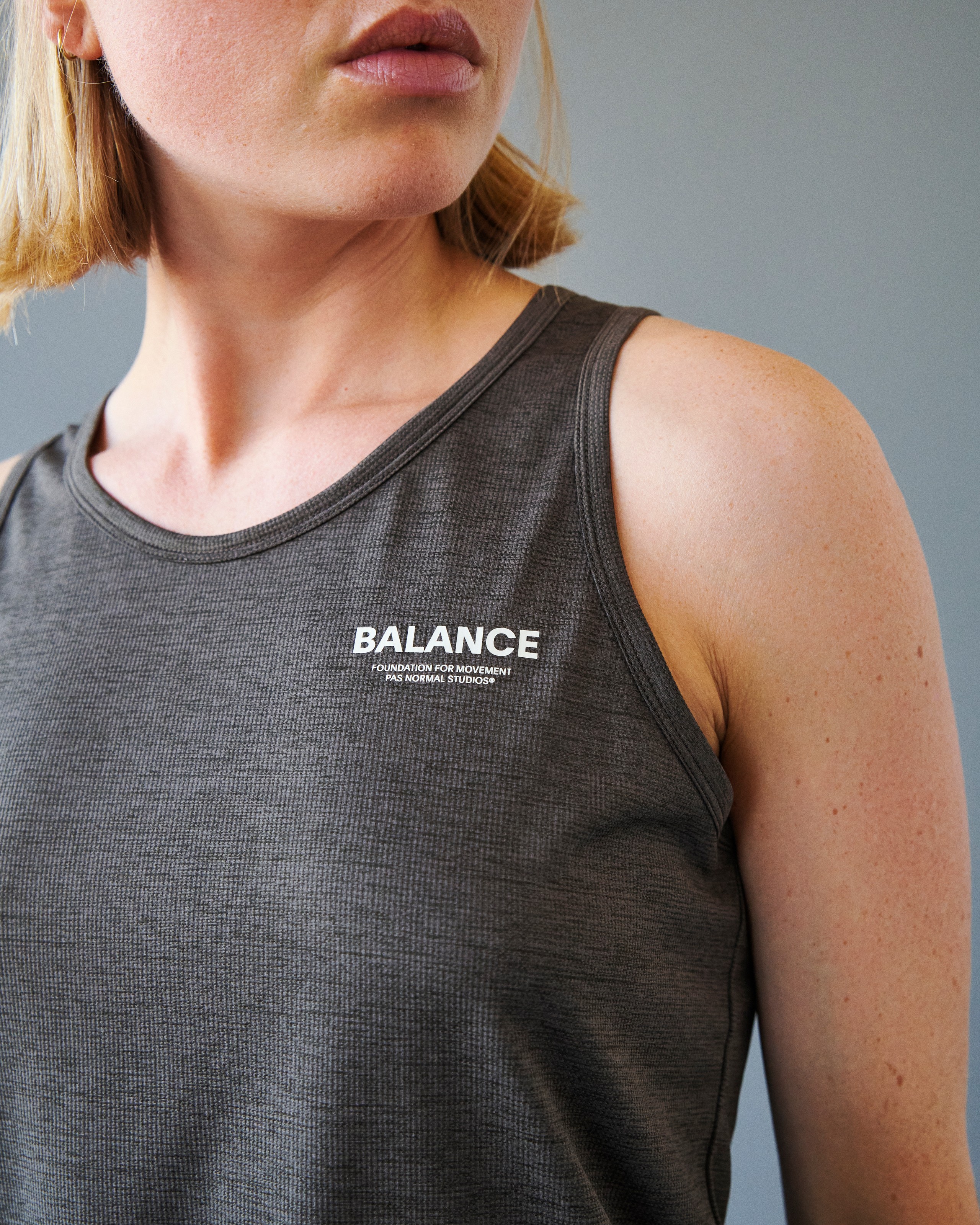 Grey Balance singlet on model with white chest logo