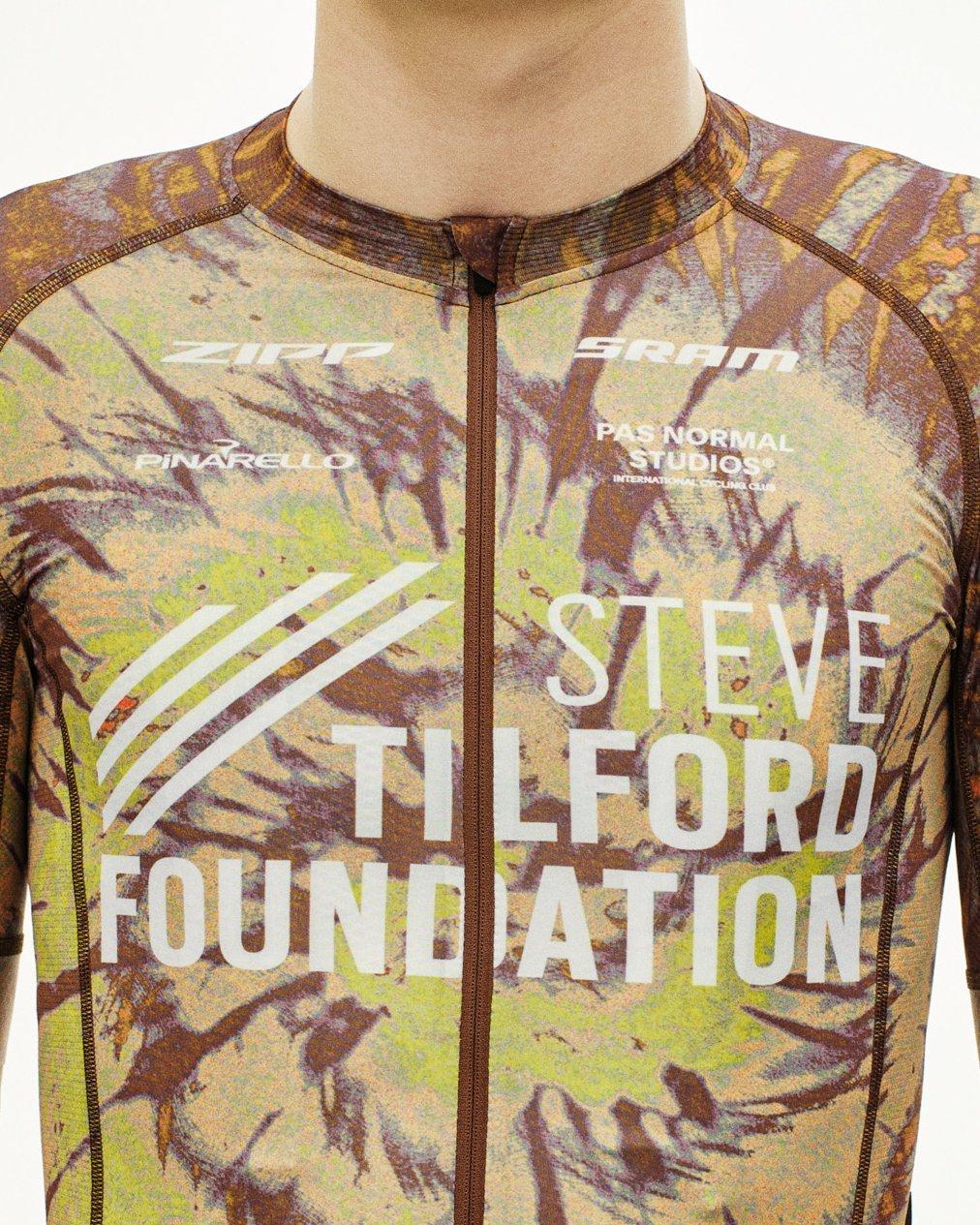 Beige STFR Mechanism long sleeve speedsuit, front view on model with camouflage print and Steve Tilford Foundation branding