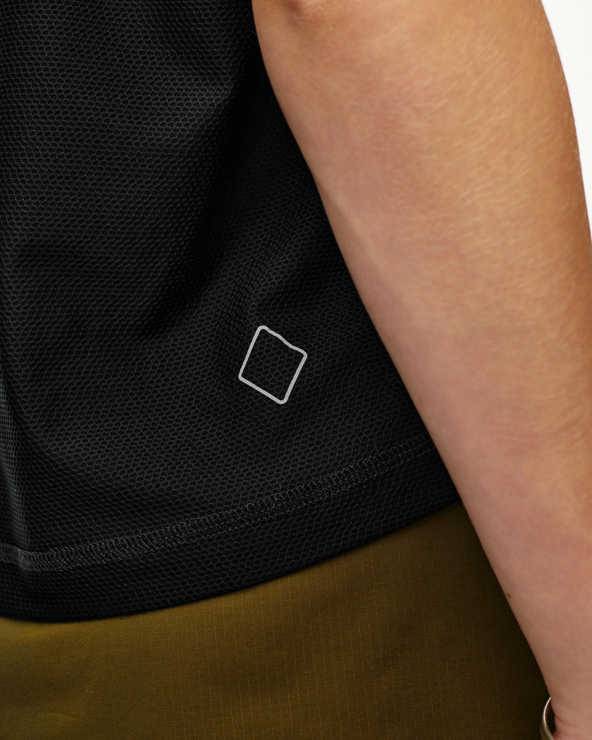 Black Balance women's T-shirt, side detail on model showing mesh fabric and small logo print at hem
