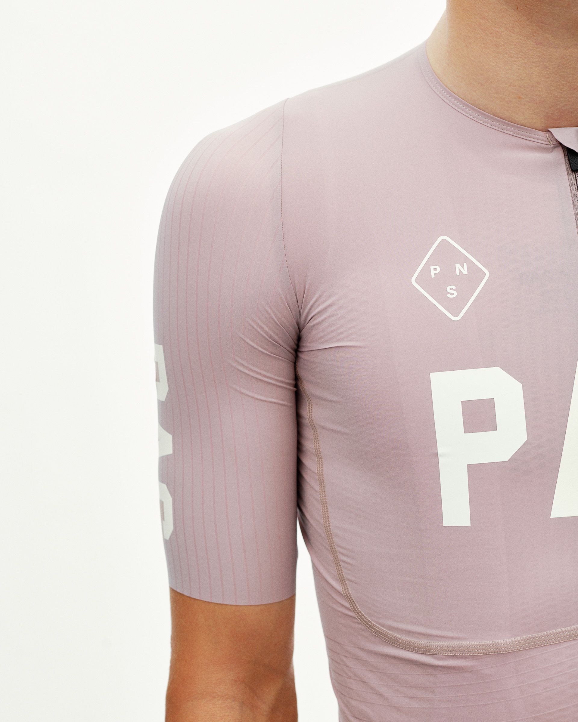 Taupe Rose PAS Mechanism Pro cycling jersey on model, side detail view with white chest print and ribbed sleeve panel