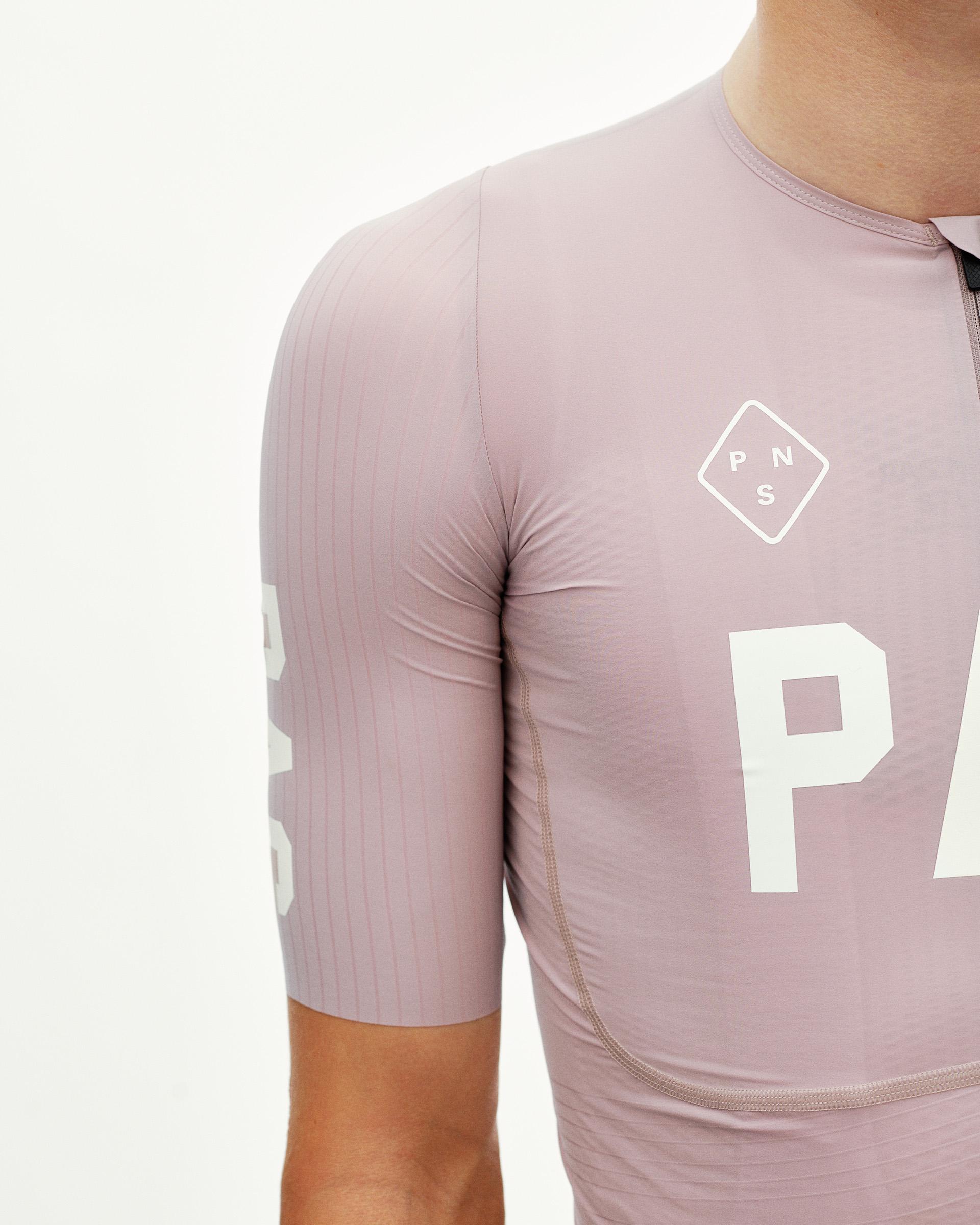 Taupe Rose PAS Mechanism Pro cycling jersey on model, side detail view with white chest print and ribbed sleeve panel