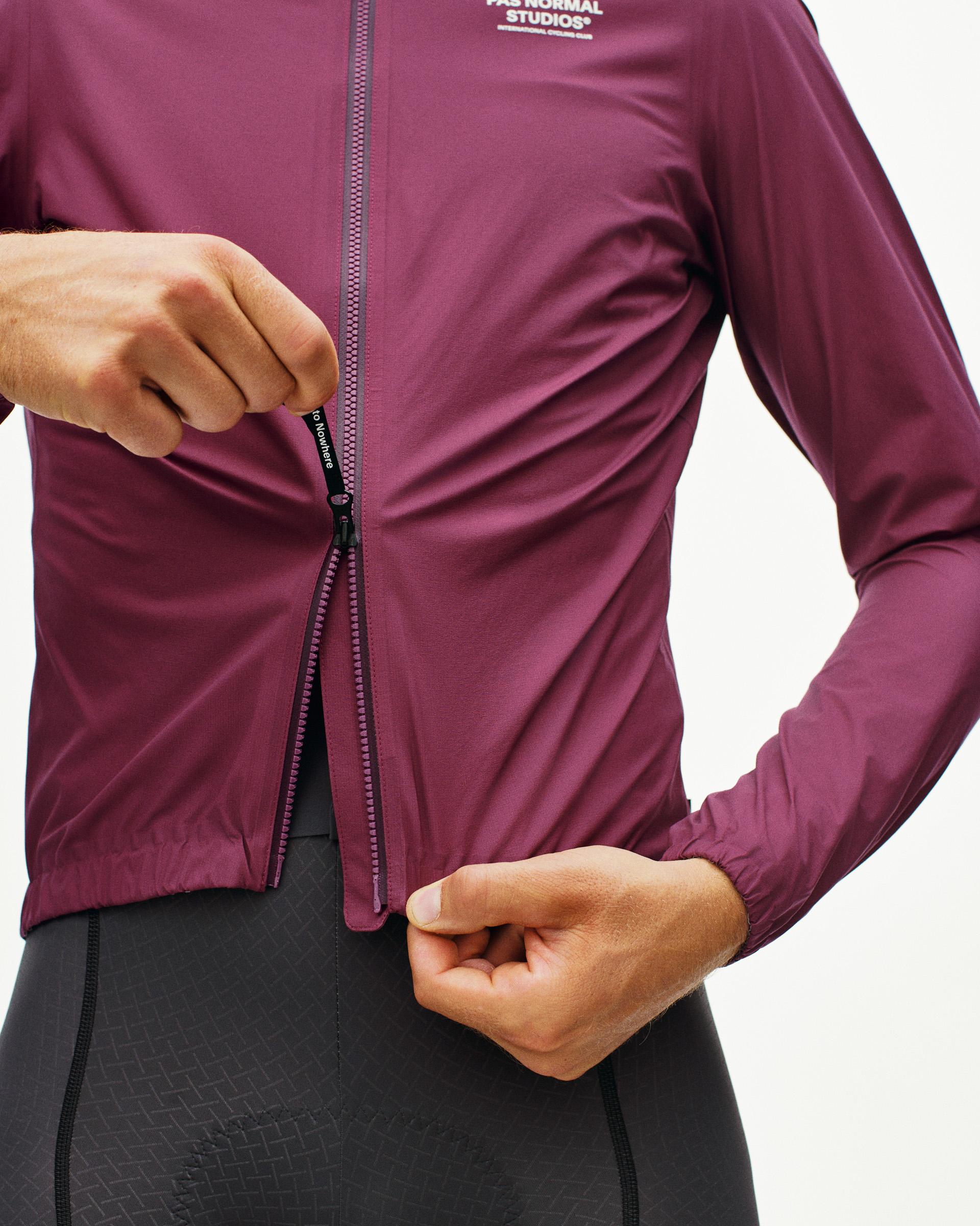 Purple Mechanism Rain cycling jacket on model with full zip and elastic hem