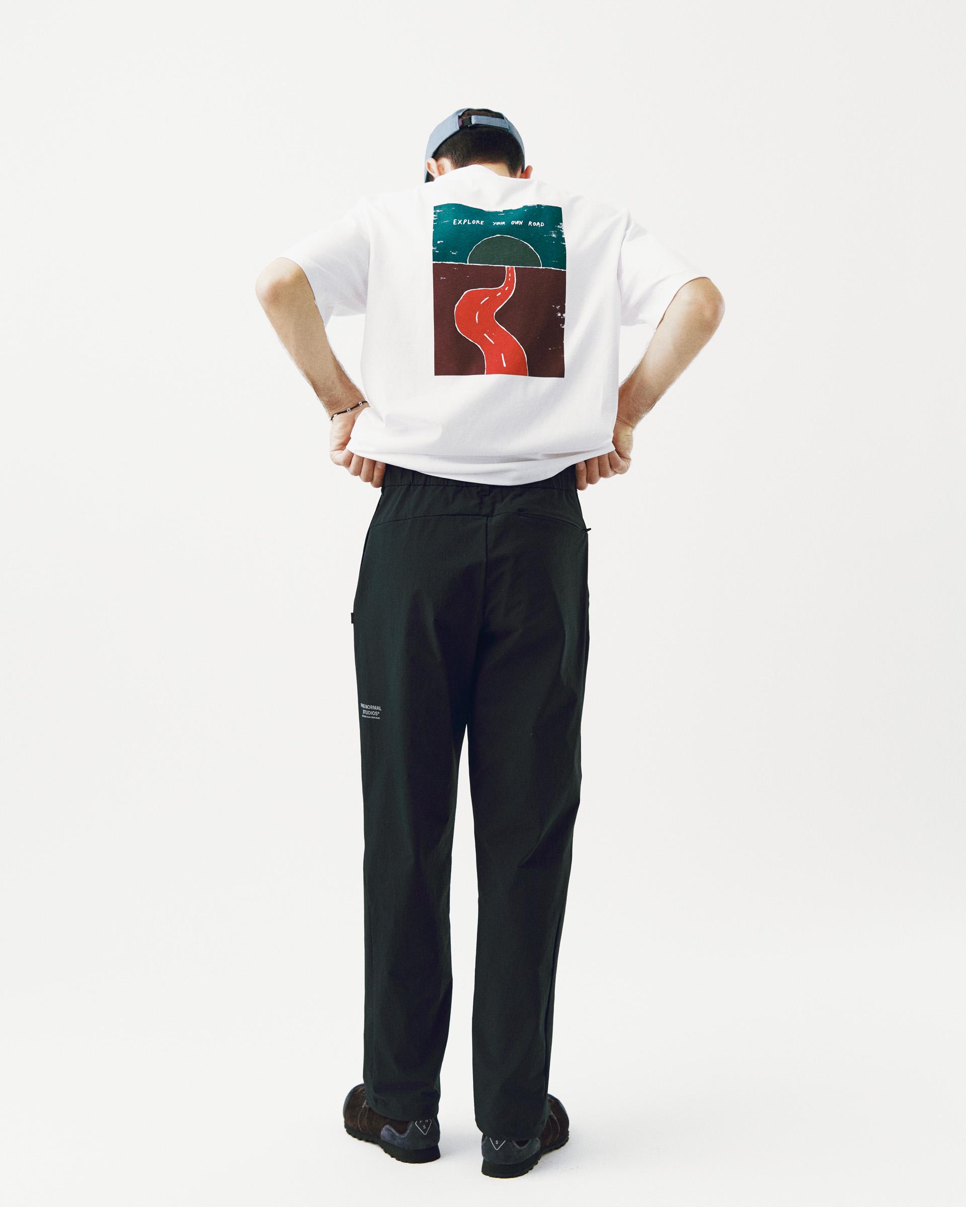 Black Off-Race Tech pants on model, rear view with white printed back graphic