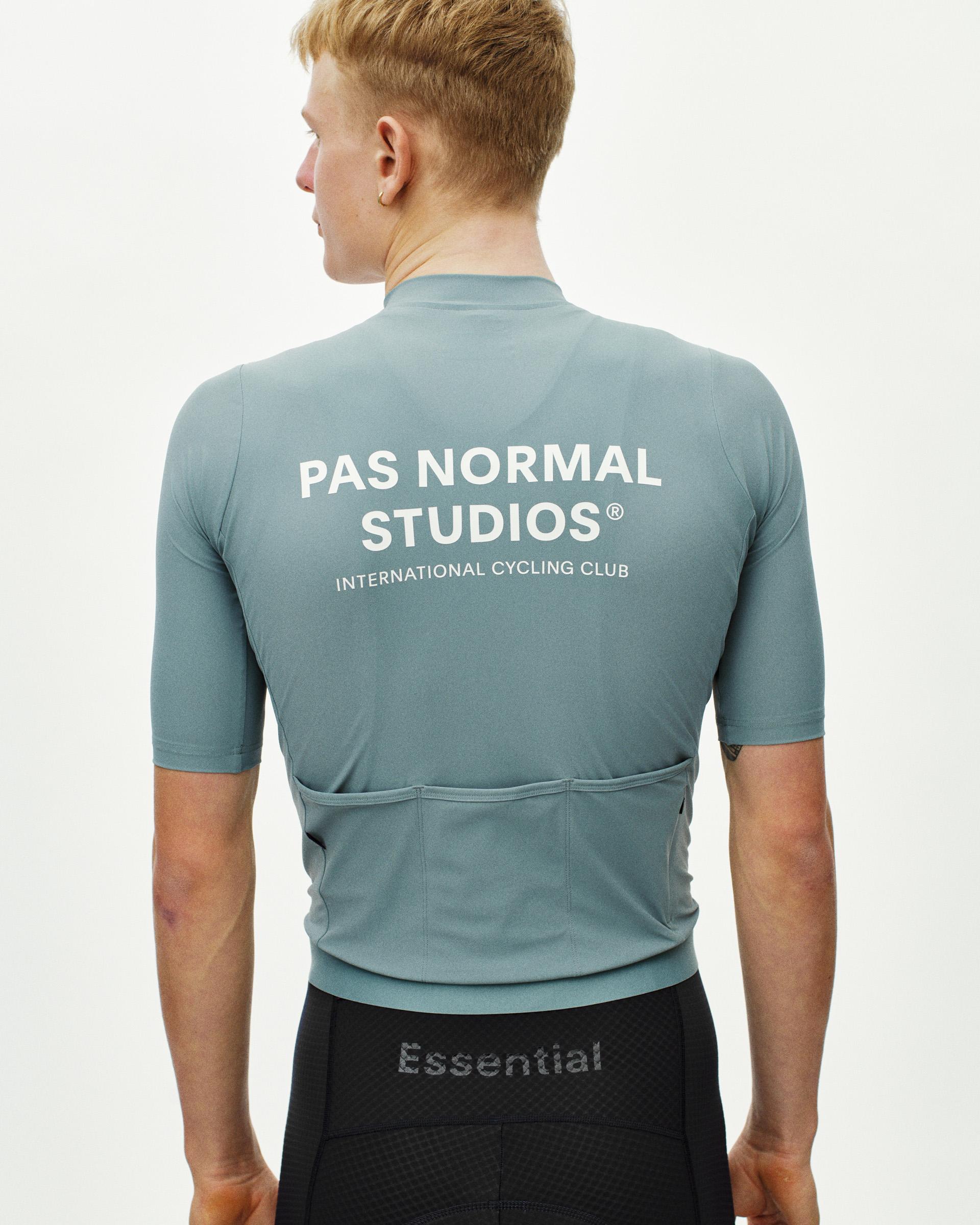 Blue Essential cycling jersey on model, rear view with white back print and rear pockets
