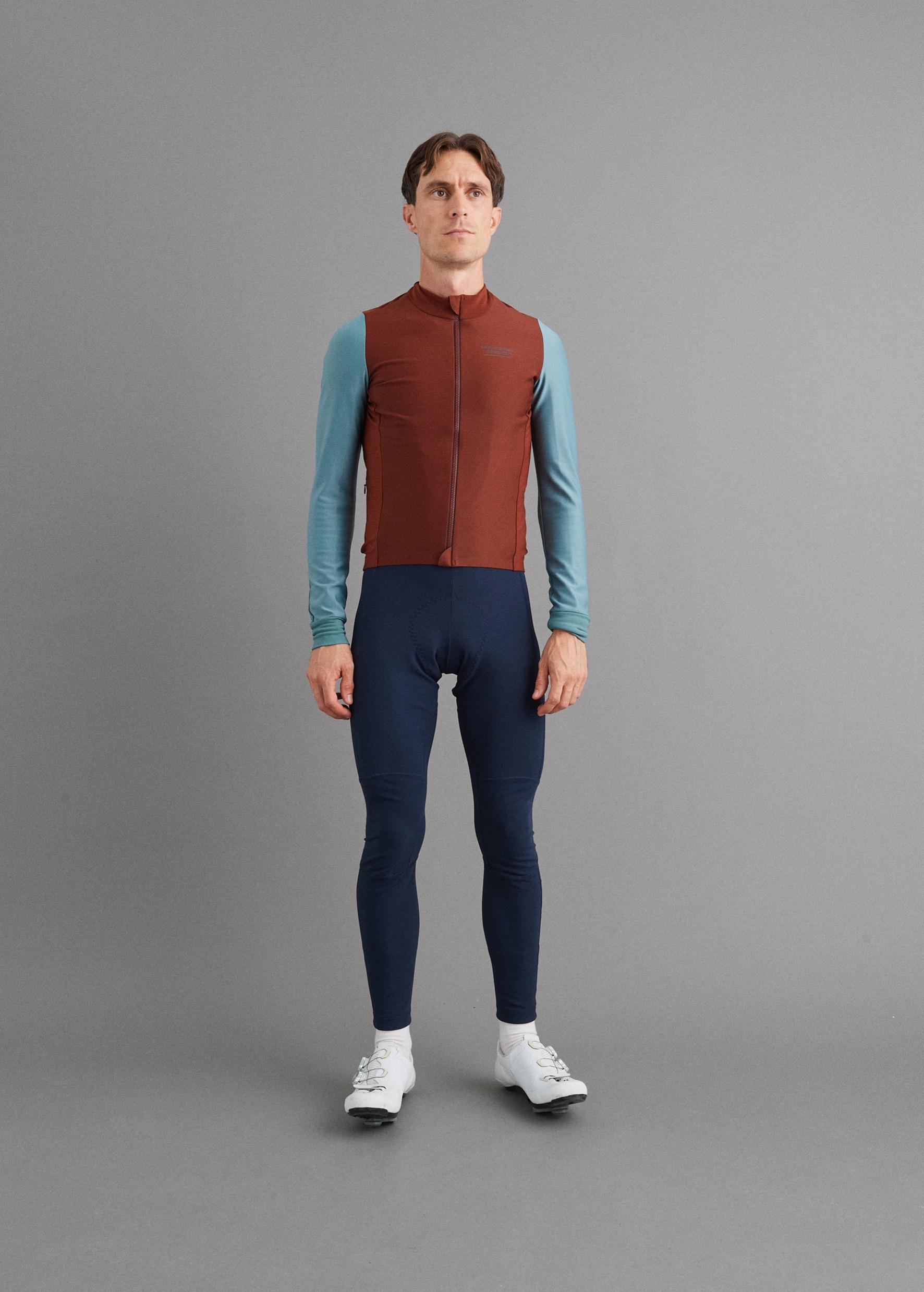 Mahogany Mechanism thermal long sleeve cycling jersey on model, front view with teal sleeves and full zip