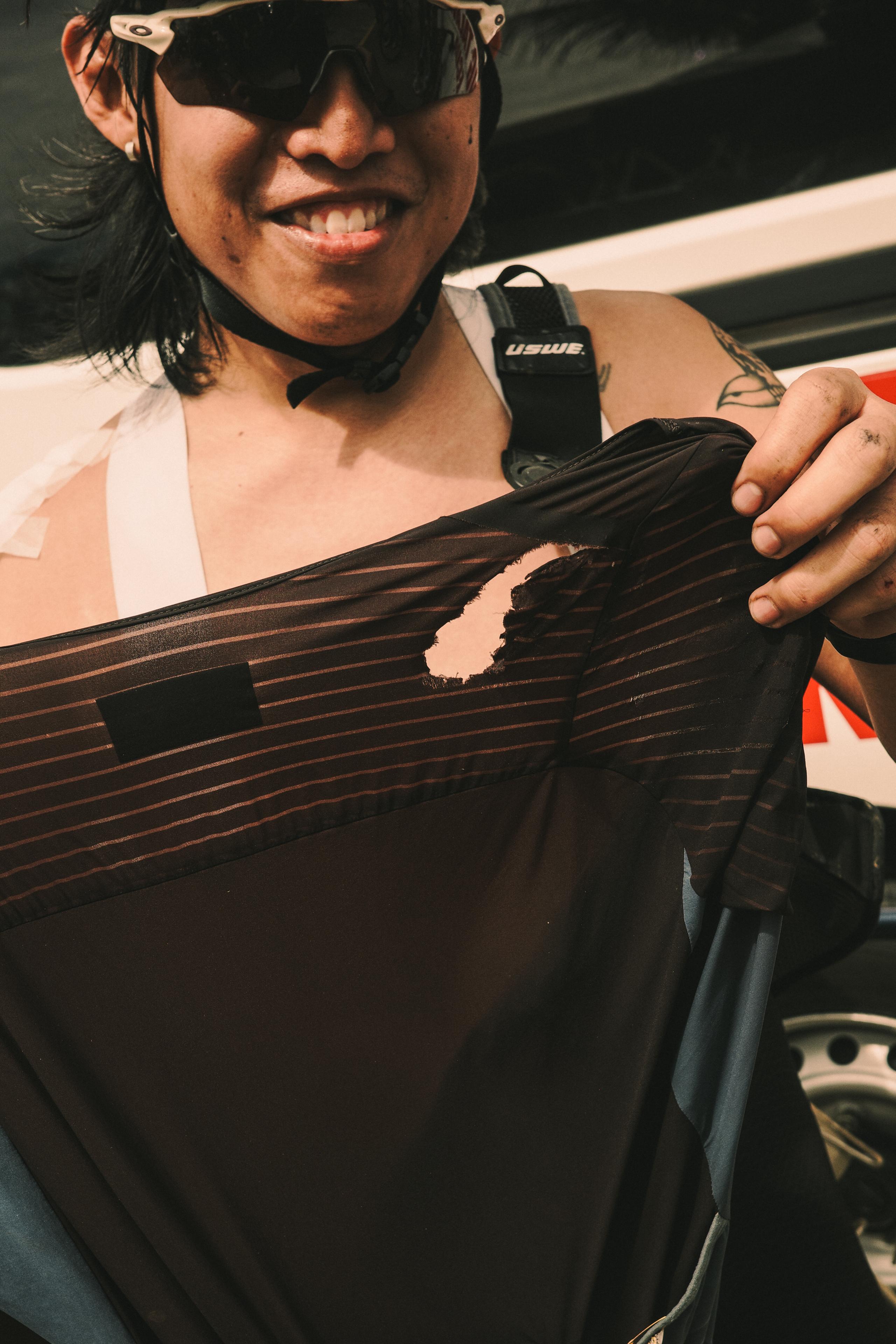 Model wearing black striped cycling jersey with geometric pattern while racing