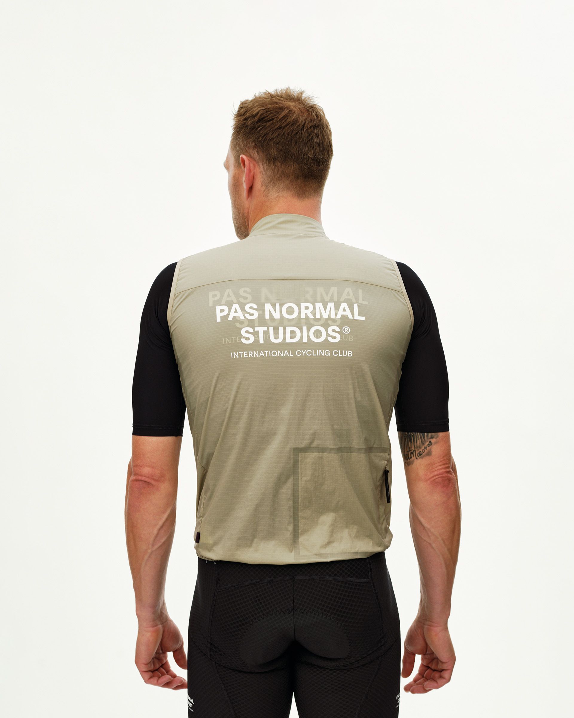 Grey Sage Essential cycling gilet on model, rear view with white chest logo print