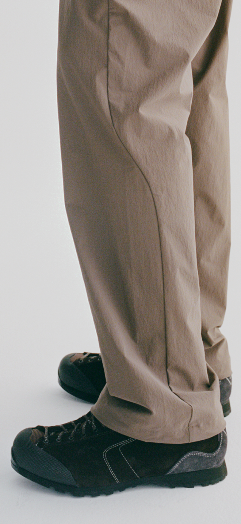 Beige trousers with dark green sneakers showing side seam detail