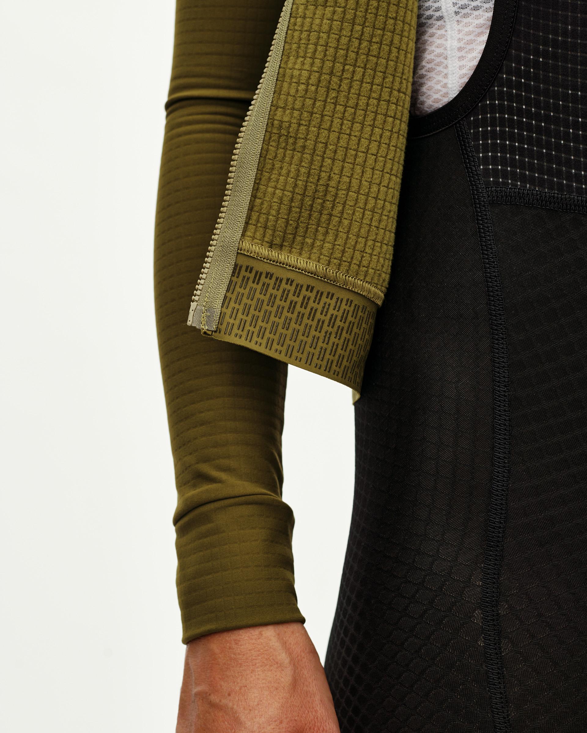 Khaki Green Essential long sleeve cycling jersey, side detail on model with waffle-knit panel and zip hem