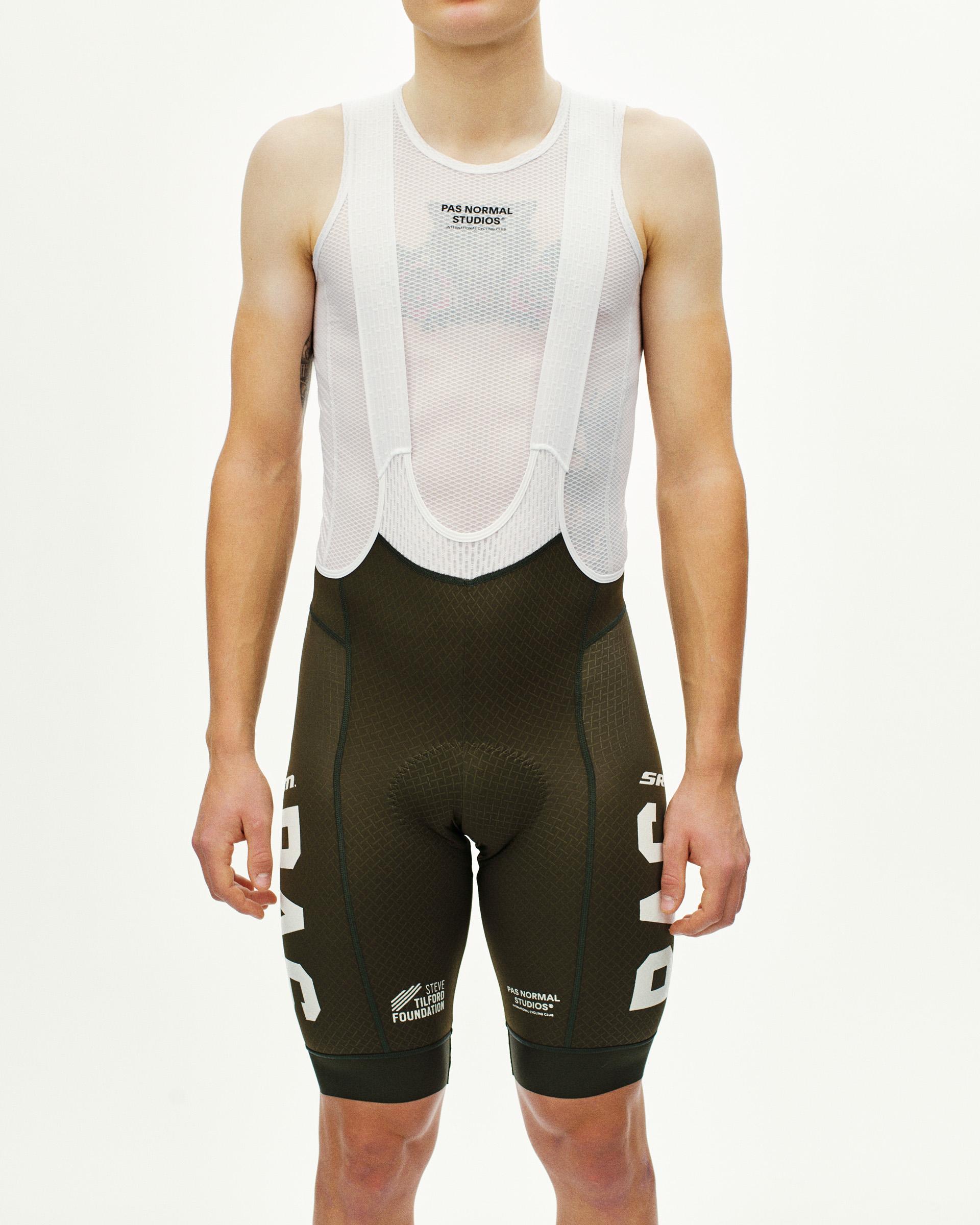 Dark Olive STFR Mechanism cycling bibs on model with white mesh bib and logo graphics