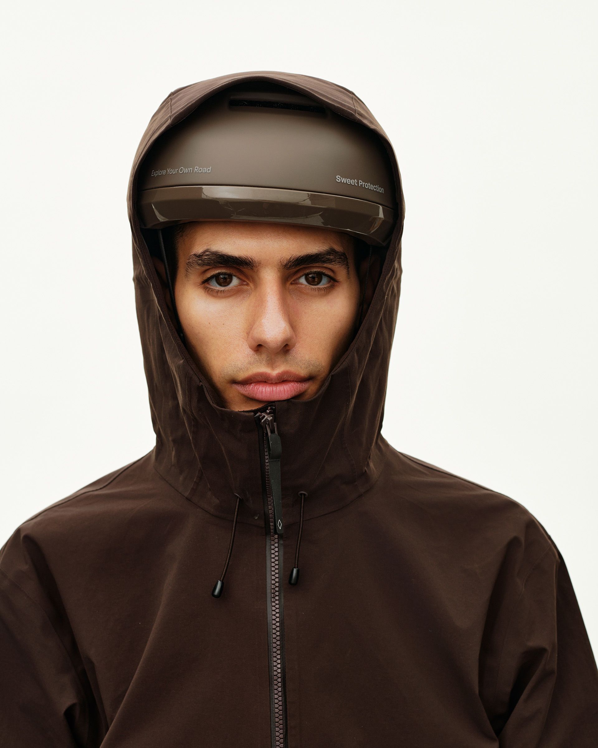 Dark Coffee brown Off-Race 3L Shell jacket on model, front detail with storm hood over cycling helmet