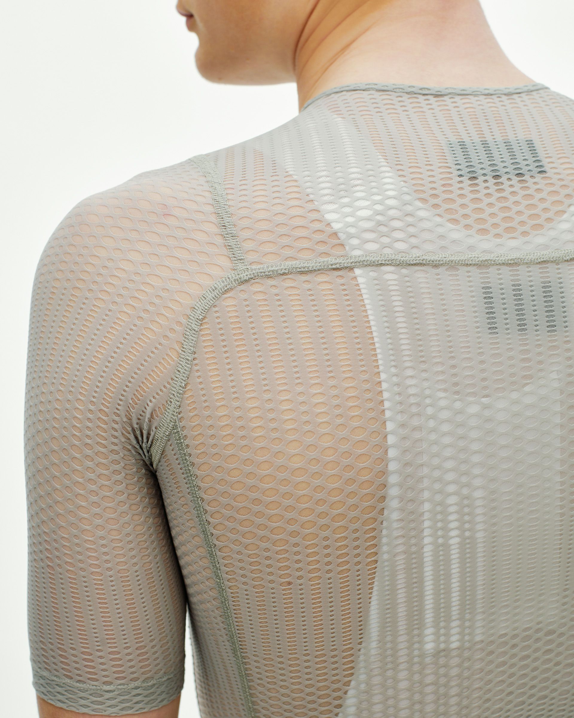 Model wearing light grey mesh base layer with seamless construction and honeycomb pattern
