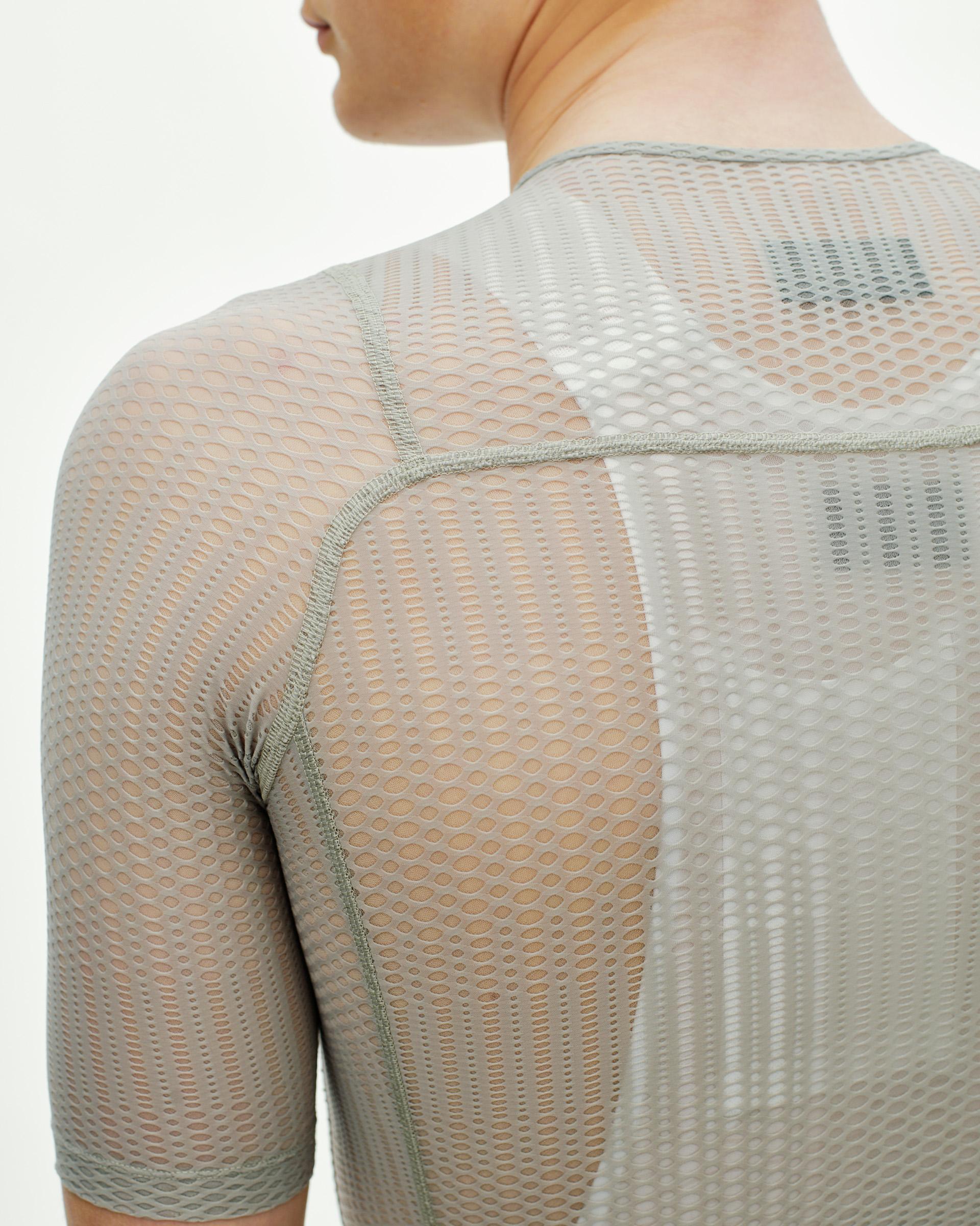 Model wearing light grey mesh base layer with seamless construction and honeycomb pattern