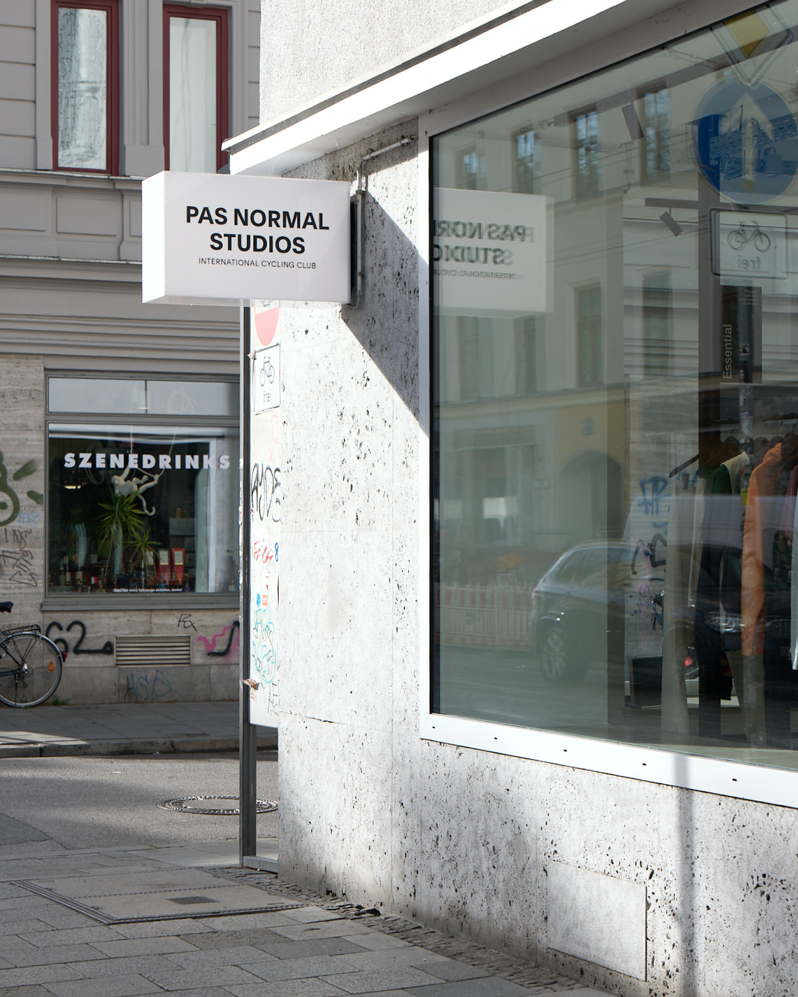 Munich store exterior with white storefront sign and large glass windows displaying cycling apparel