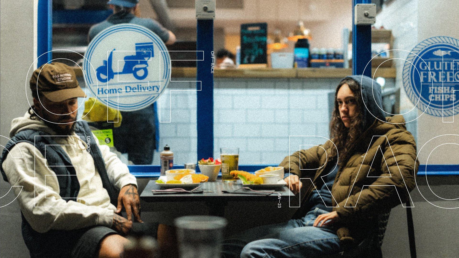 Two people sitting at table in restaurant wearing casual streetwear from Off-Race AW23 collection