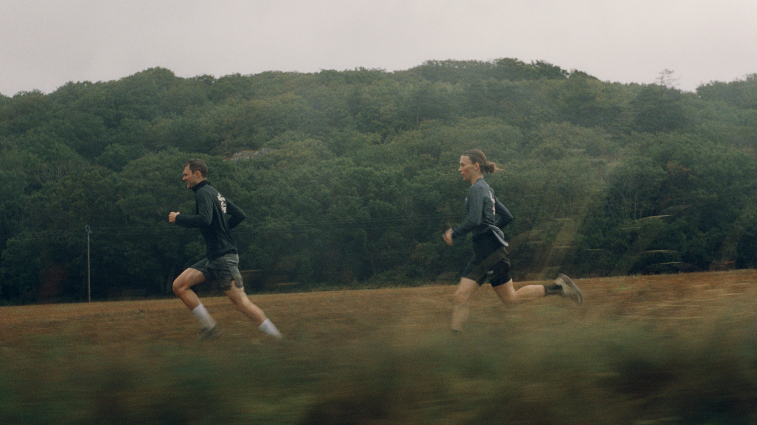 Balance t-shirt worn by runners in countryside field setting
