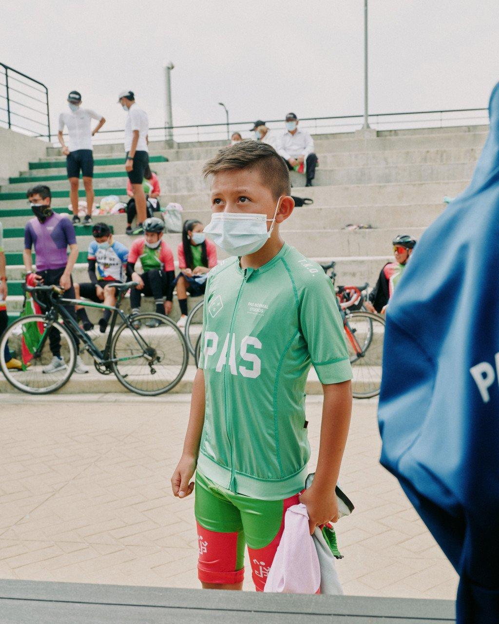 Young cyclist wearing green PAS collection jersey and matching shorts at cycling event