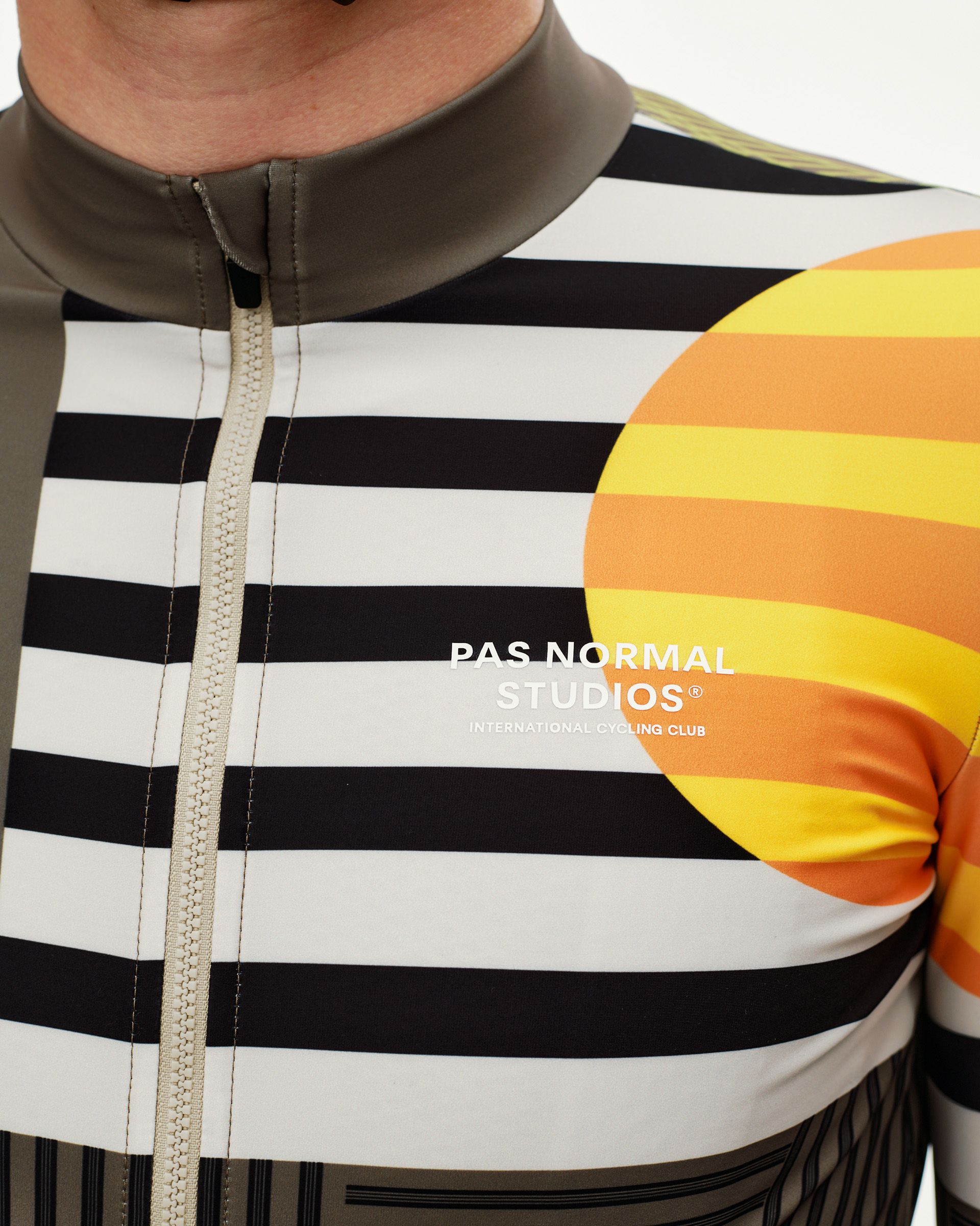 International Sand Mechanism long sleeve cycling jersey, front detail on model with black stripe and orange circle graphic