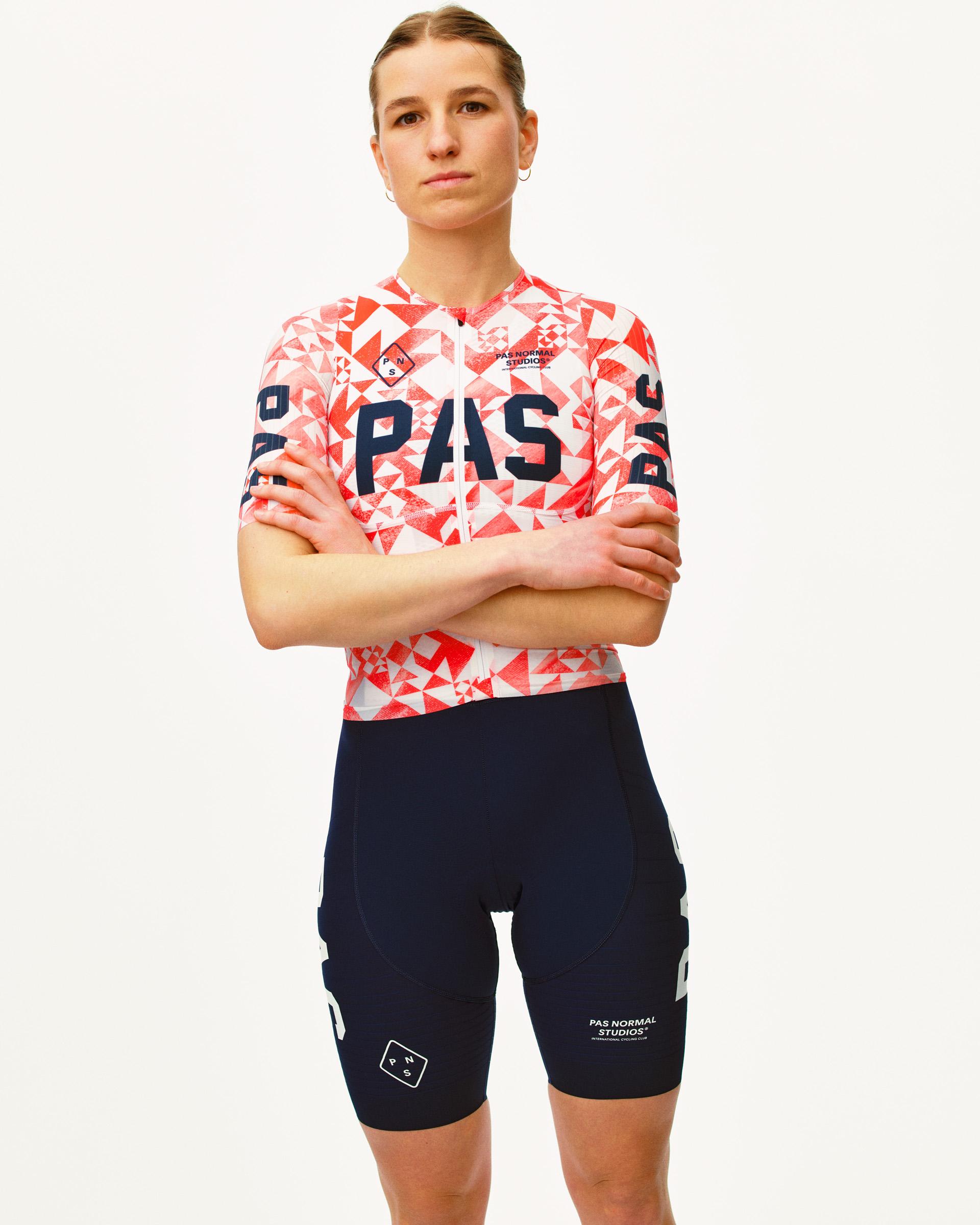 Red PAS Mechanism Pro cycling jersey on model with geometric origami print and navy PAS lettering