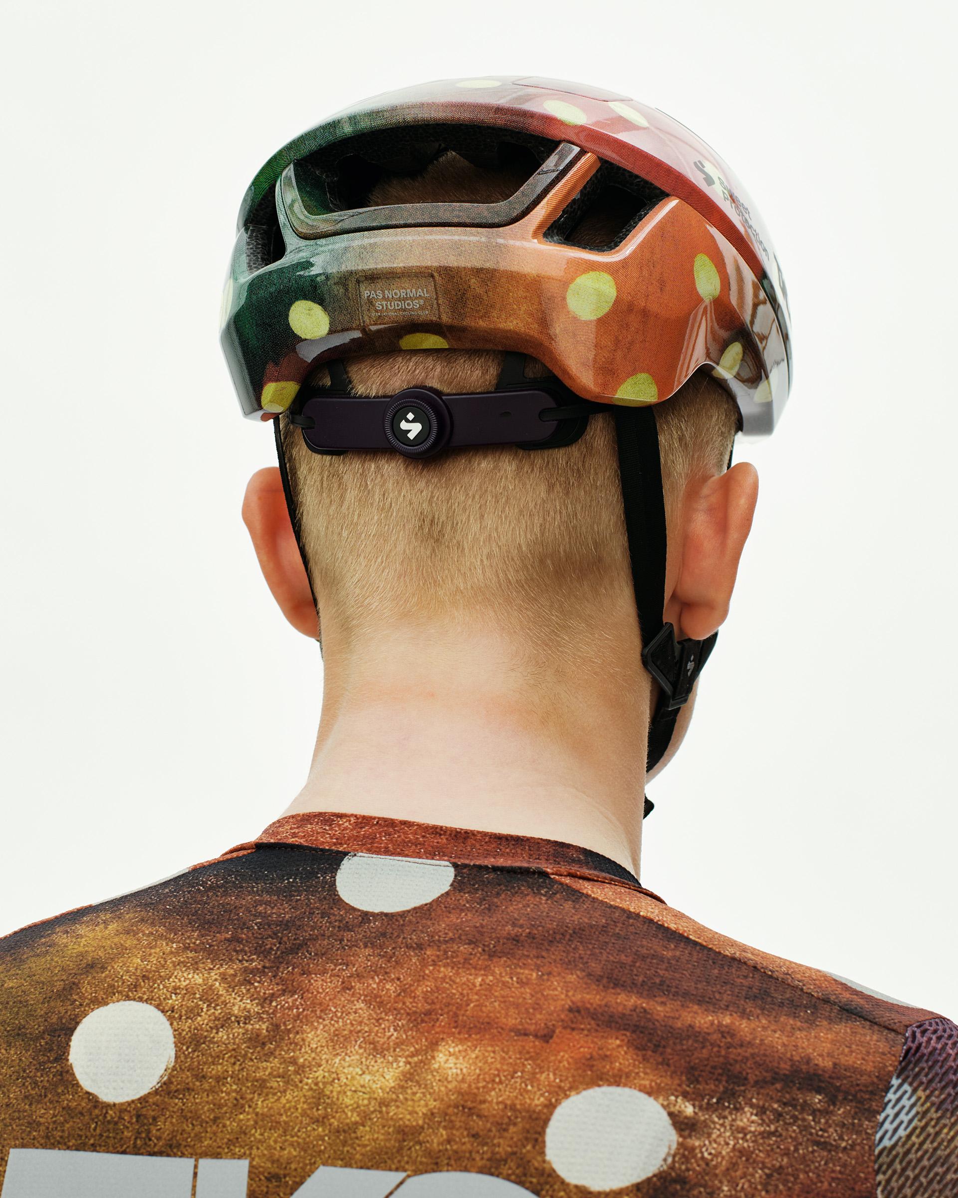 Brown T.K.O. Falconer Aero 2Vi cycling helmet, rear view on model with polka dot pattern