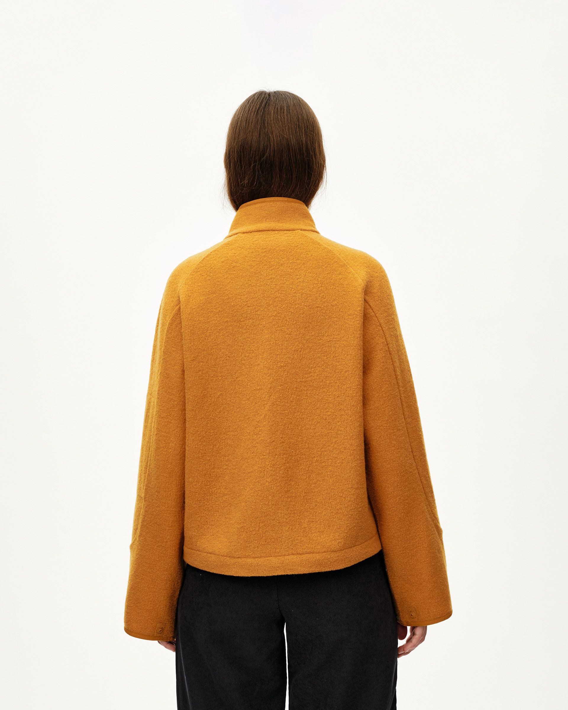 Ochre Off-Race Boiled Wool jacket on model, rear view with stand collar and snap cuffs