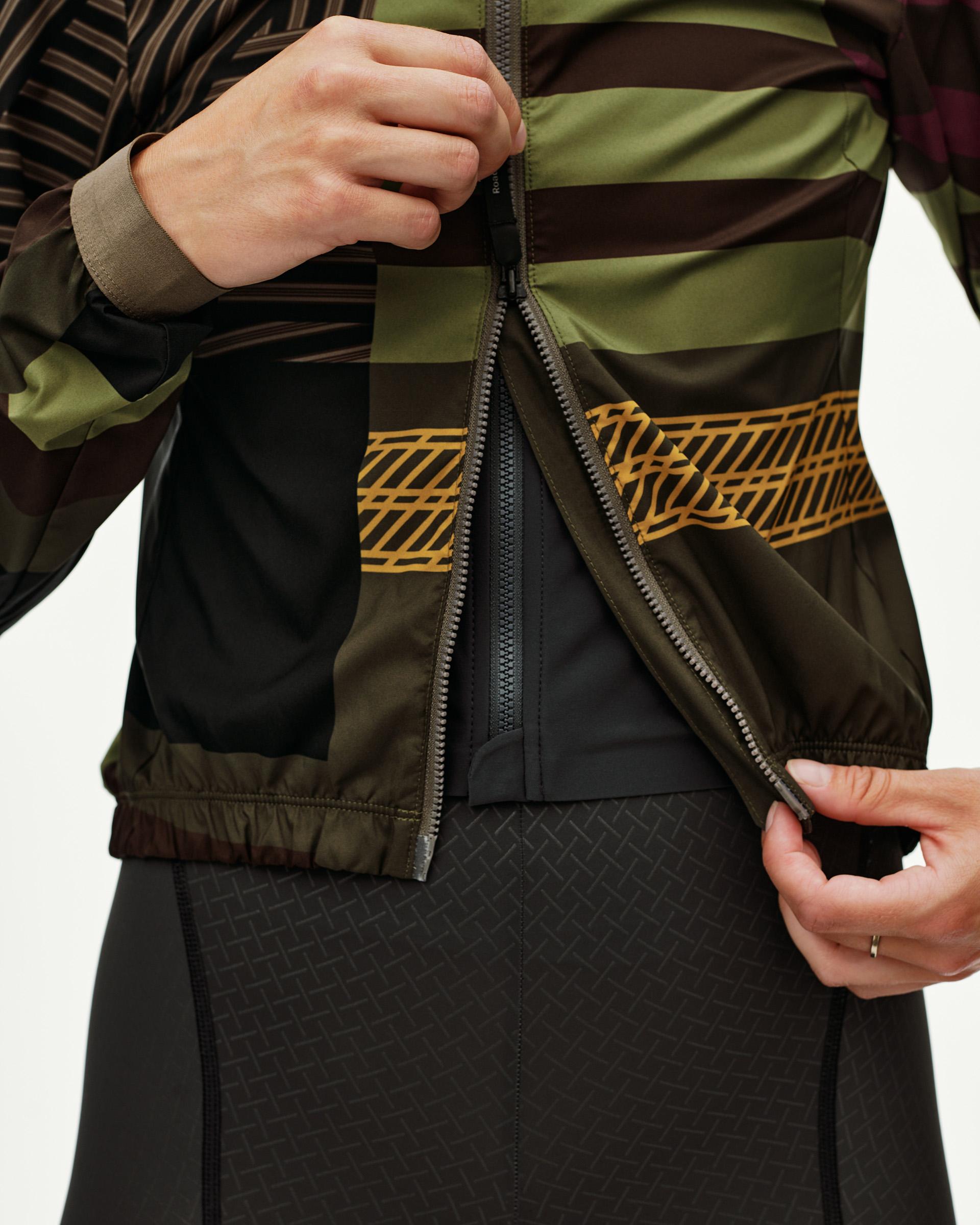 International Green Mechanism Stow Away cycling jacket, front detail on model with open zip and gold graphic band