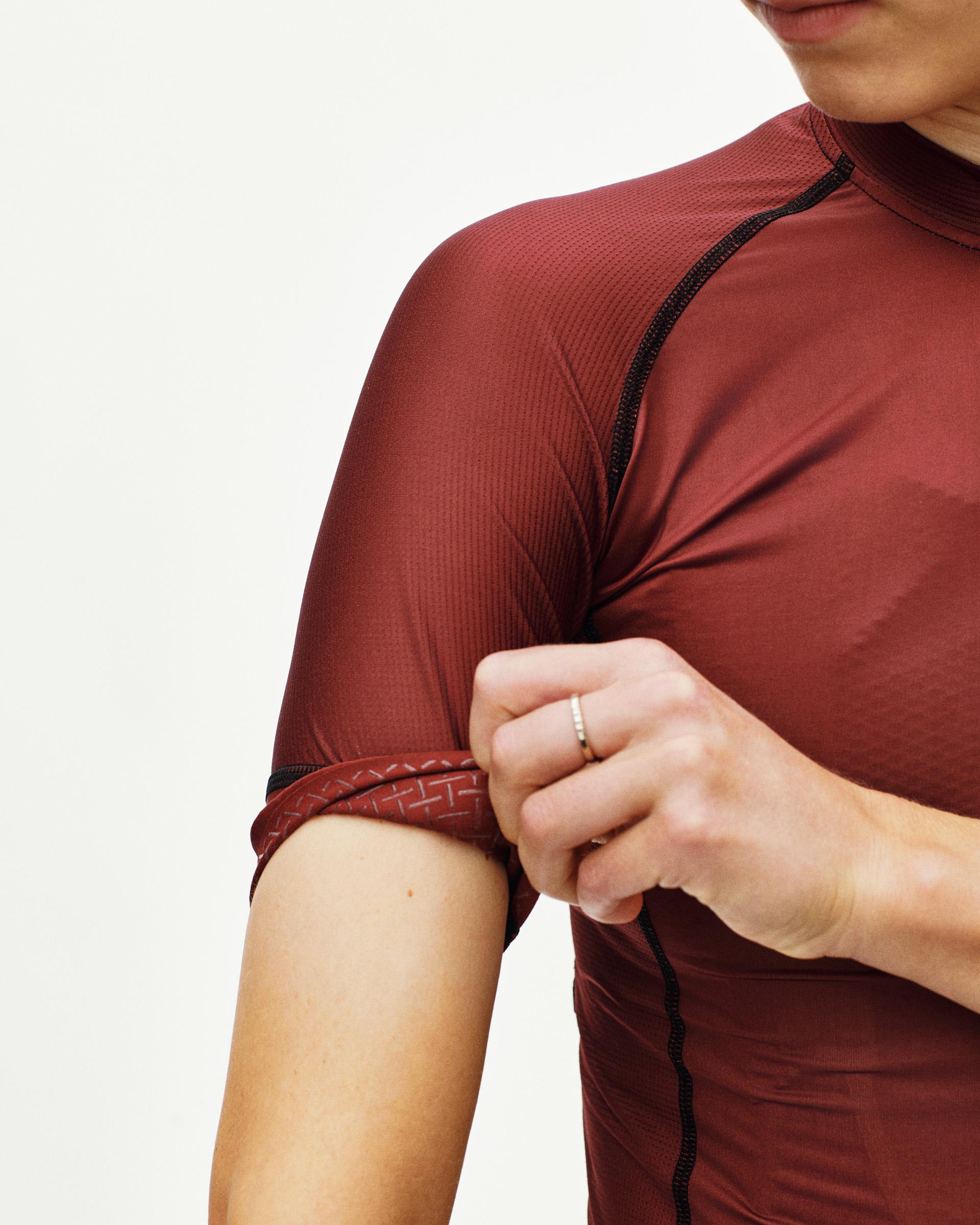 Maroon Mechanism cycling jersey on model with textured sleeve hem detail