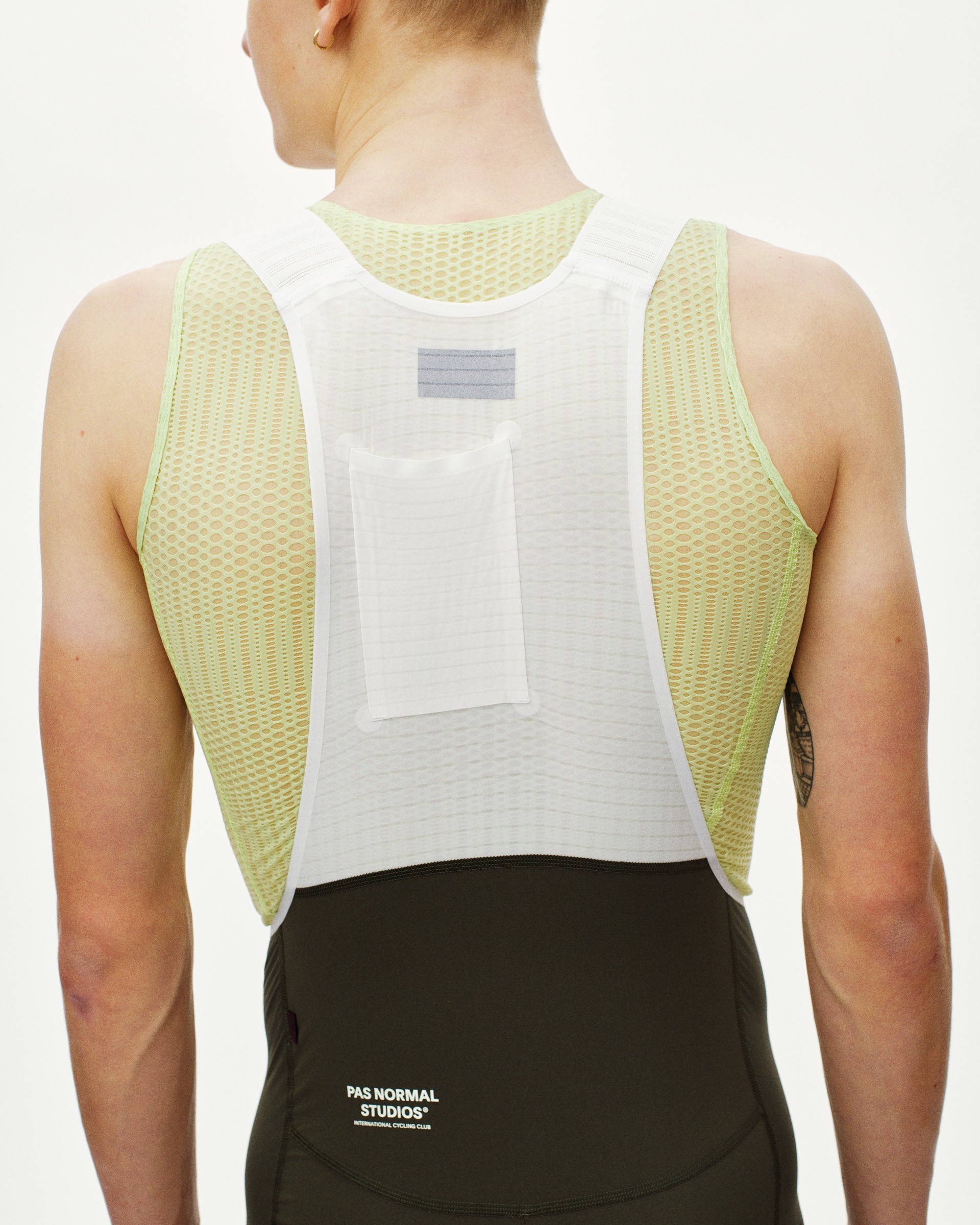 Green Mechanism Pro Sleeveless cycling baselayer on model, rear view with mesh side panels