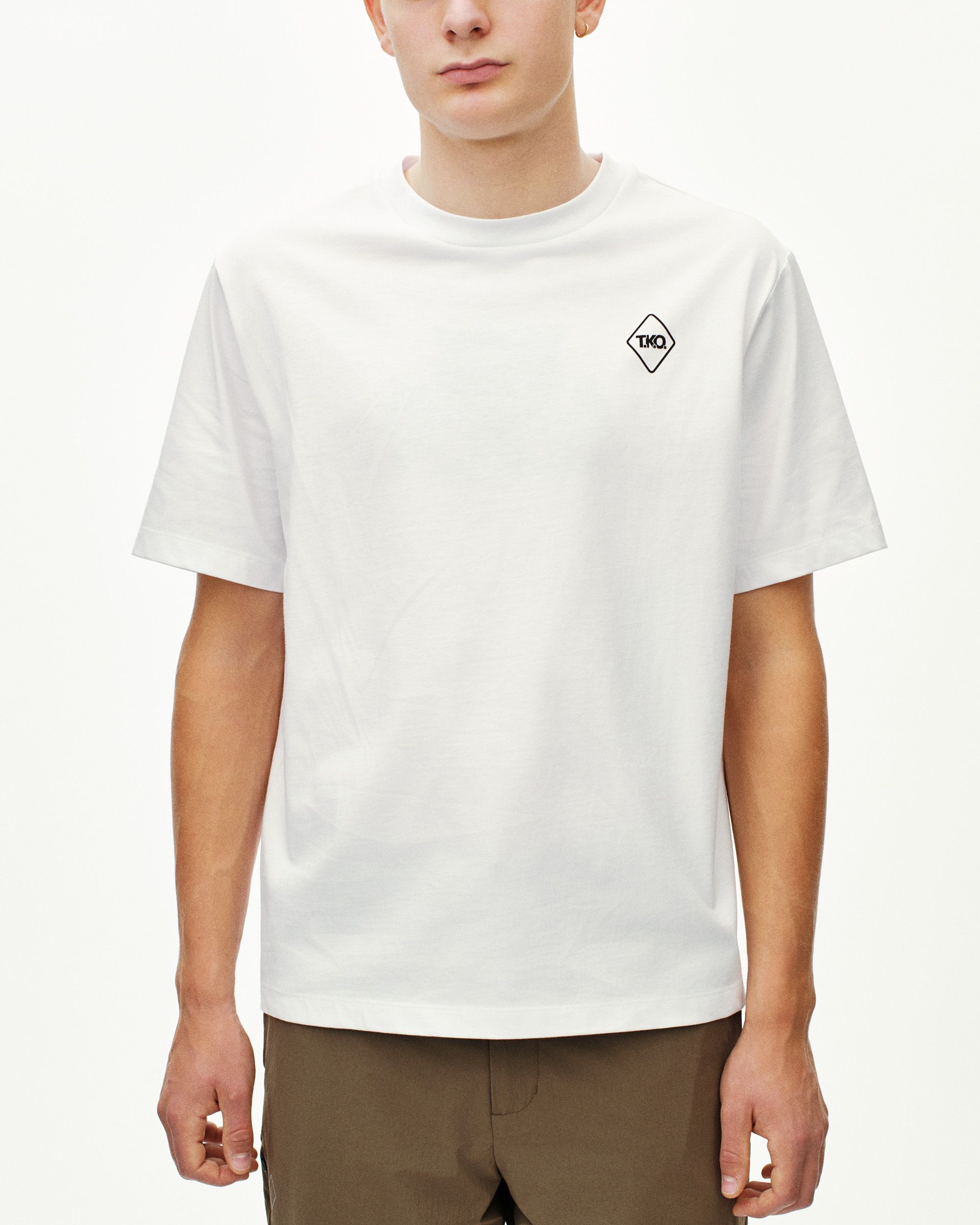 White T.K.O. Off-Race Graphic T-shirt on model, front view with black diamond logo patch on chest