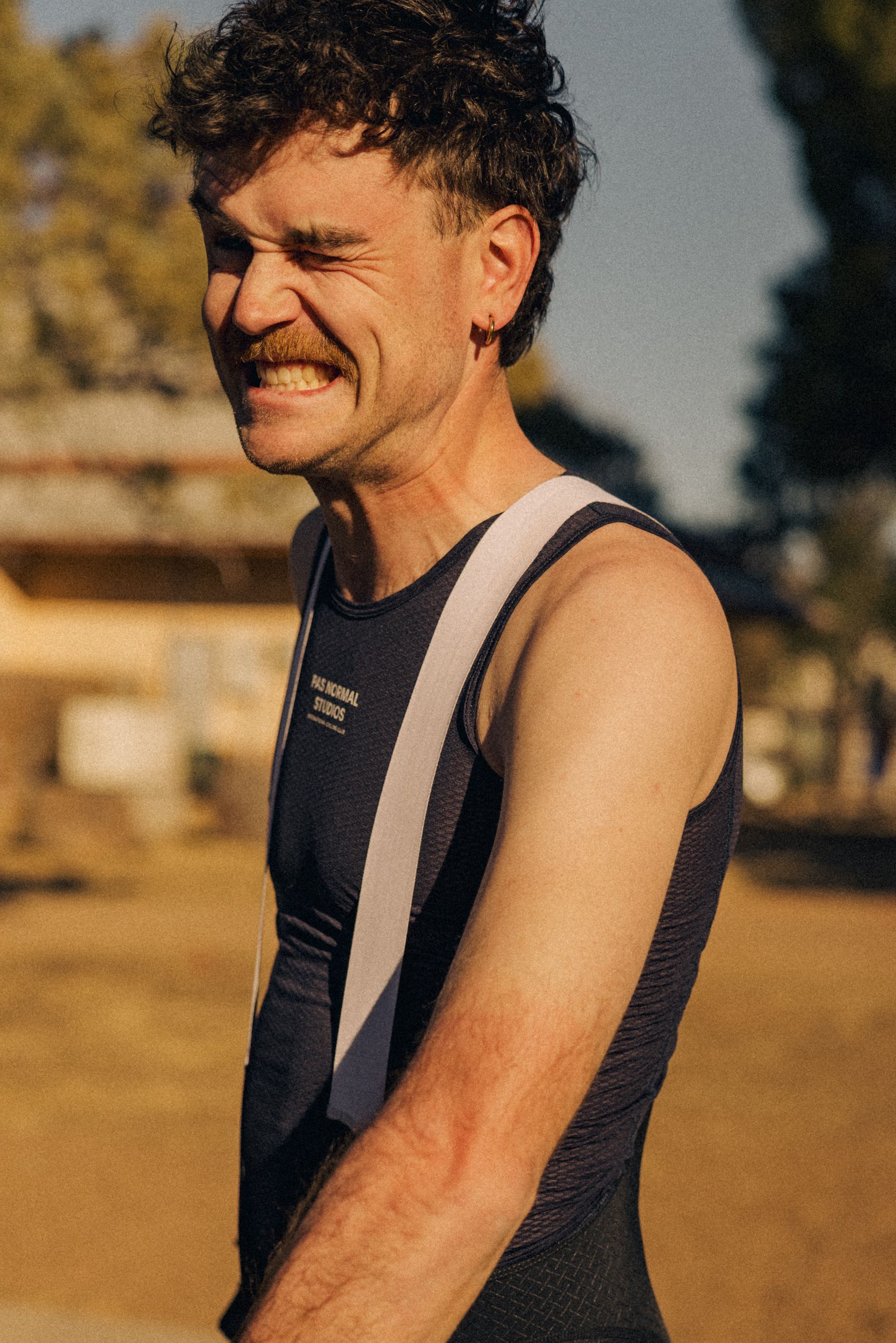 Model wearing Men's black sleeveless cycling jersey with white stripe and chest branding
