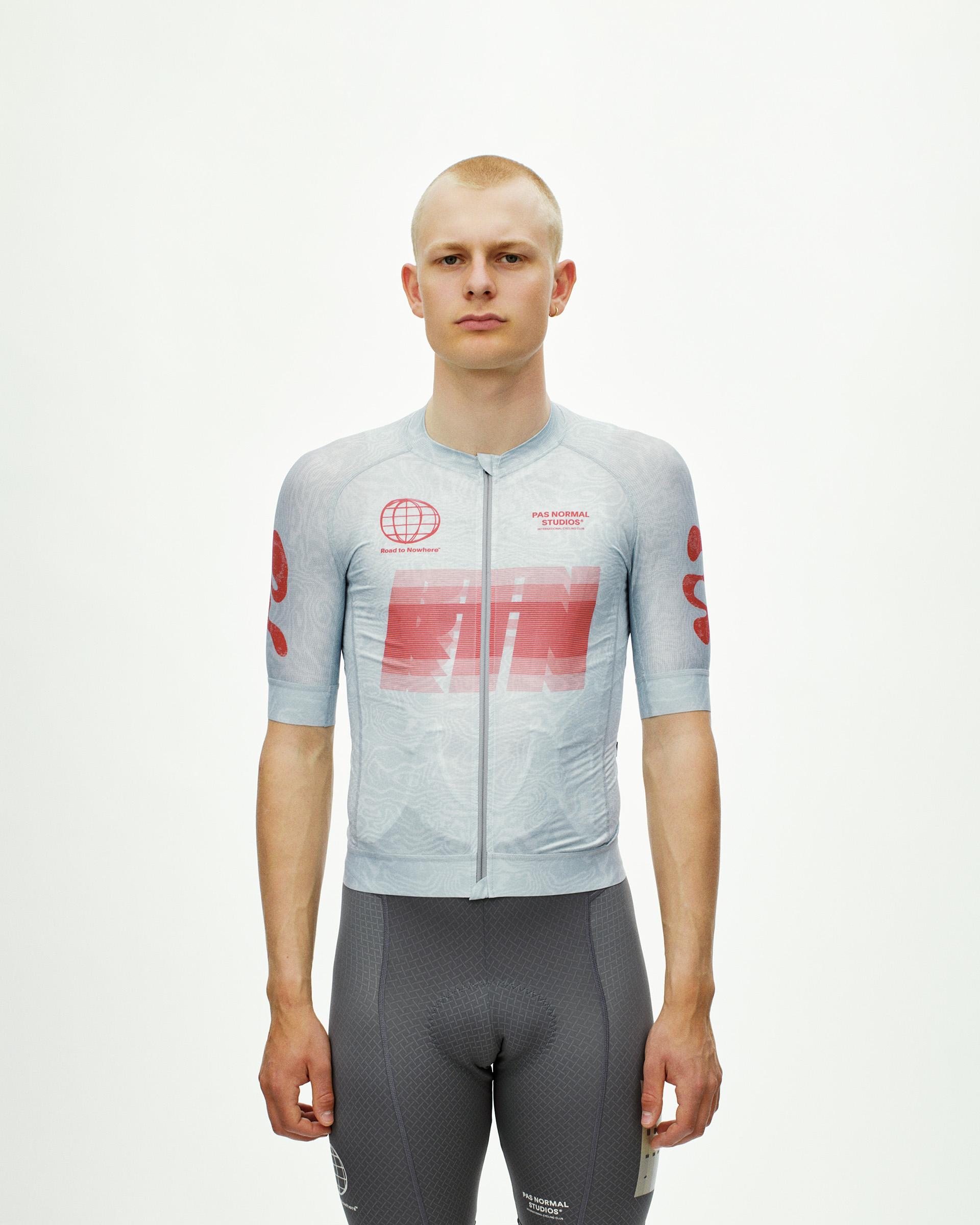 Light Aqua Mechanism cycling jersey on model, front view with large red RTN chest graphic and globe logo