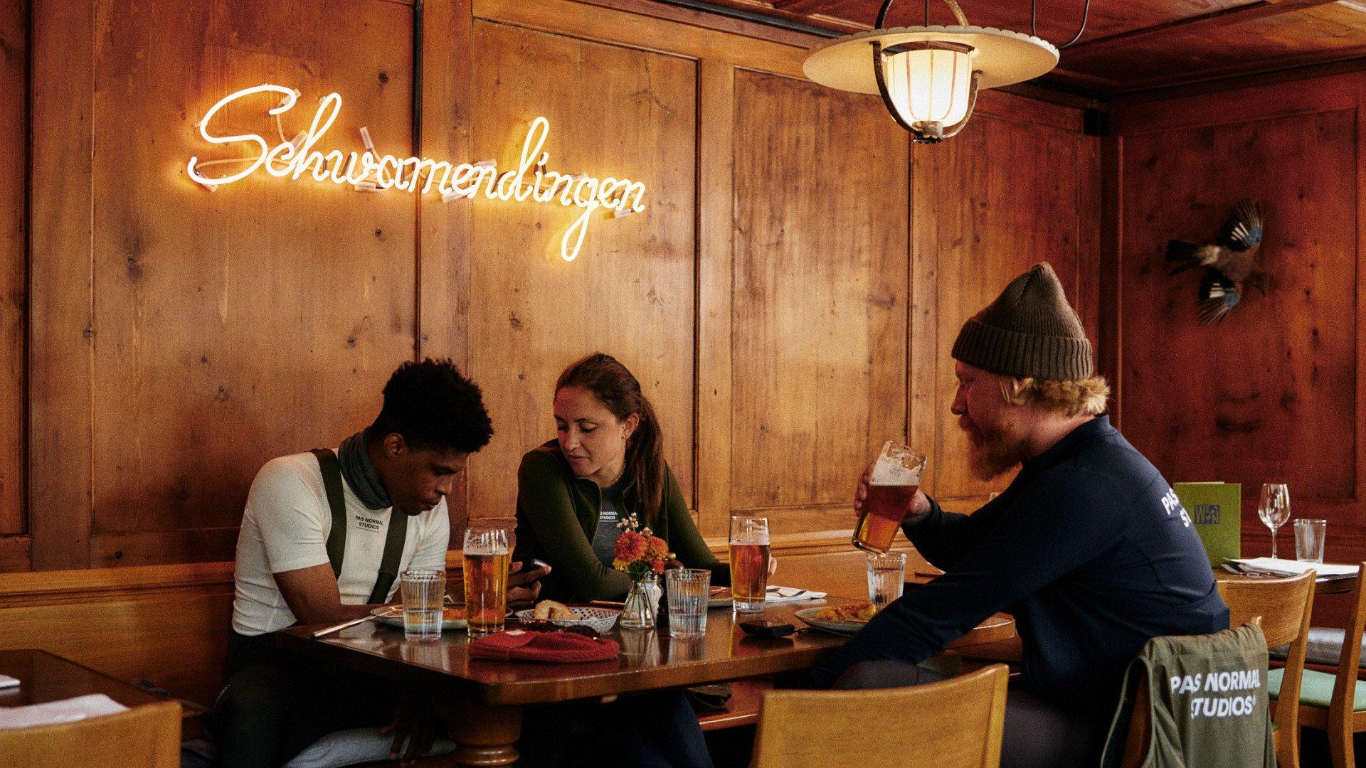 Cyclists relaxing with drinks in a traditional wooden tavern in Zürich