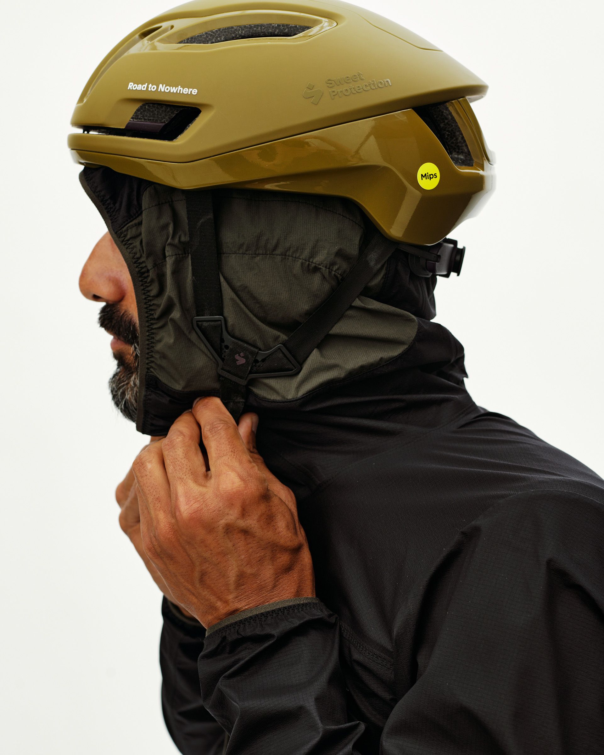 Black Escapism Hooded Lightweight jacket on model, side view with helmet-compatible storm hood zipped up