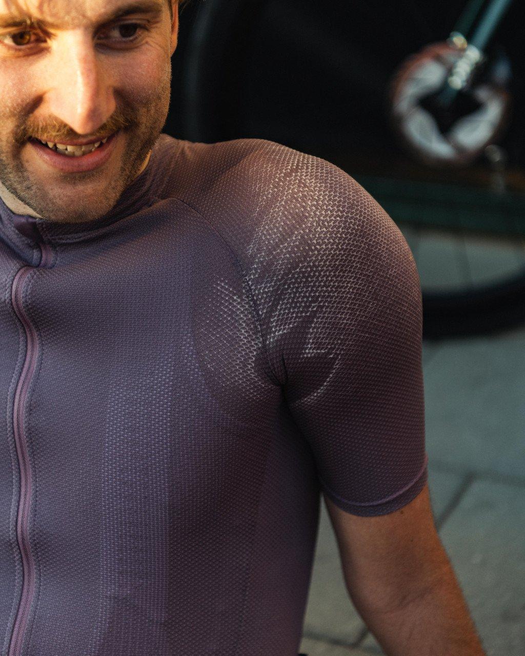 Model wearing purple cycling jersey with textured knit fabric and full zip closure
