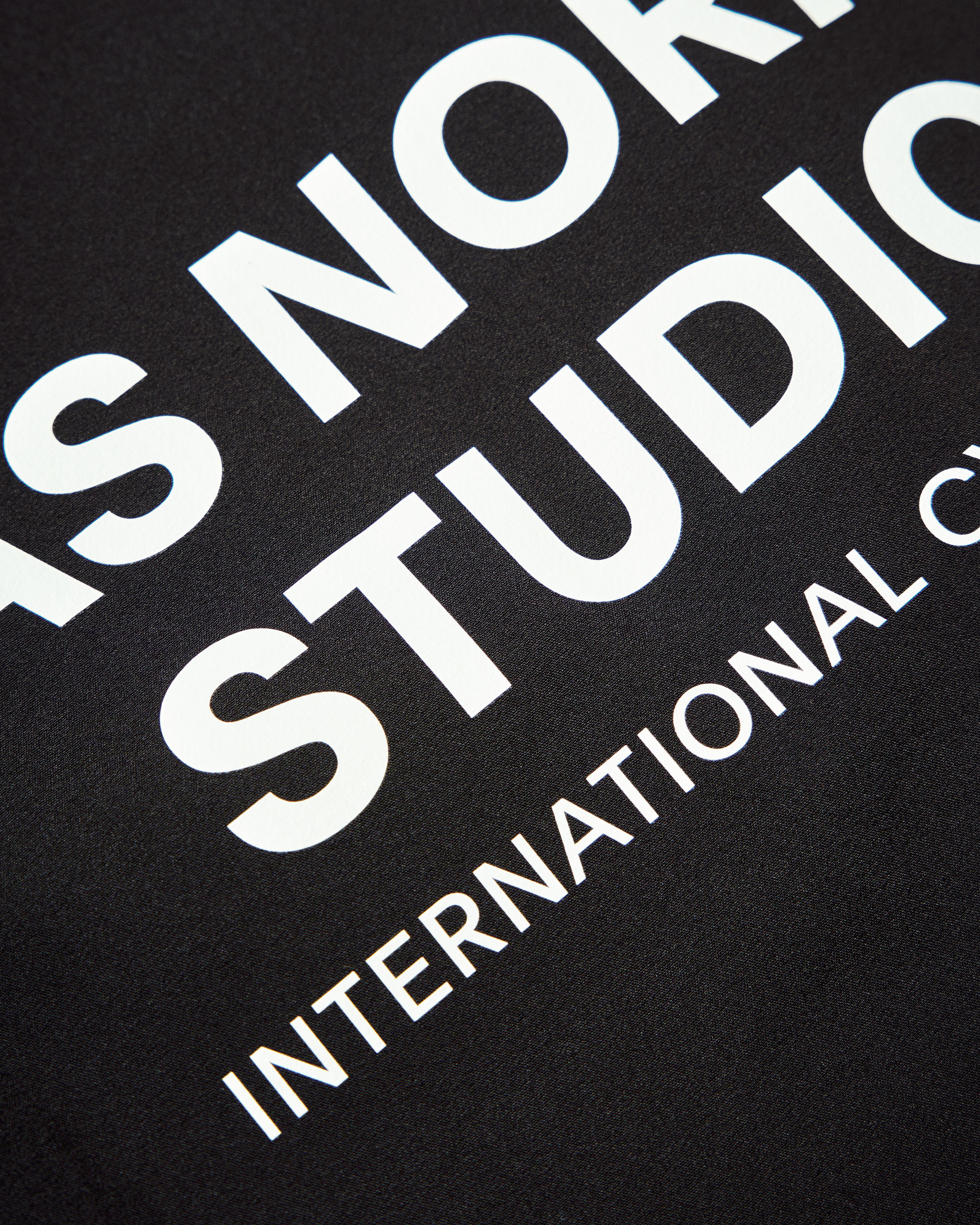 Black Mechanism Stow Away jacket, detail view with white printed text