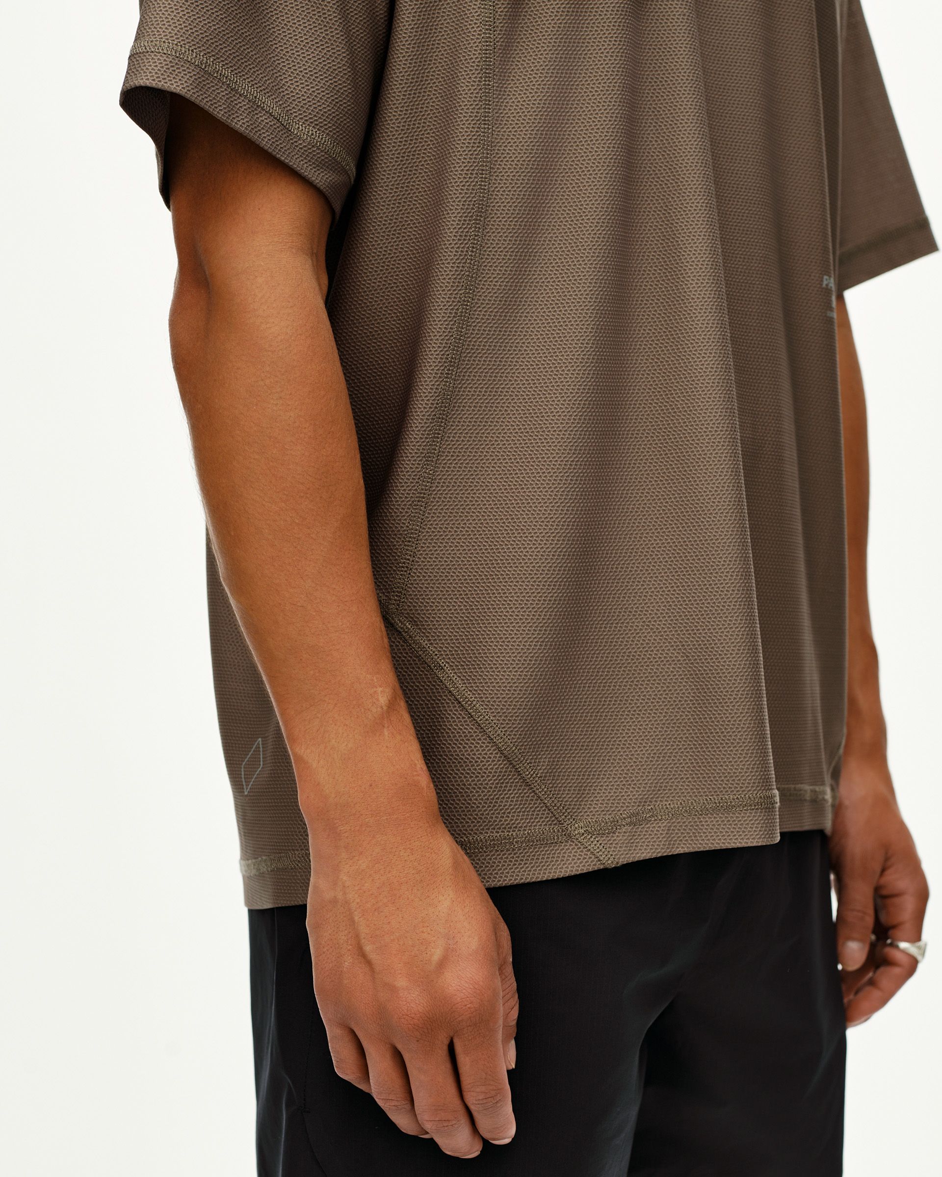 Stone Brown Balance T-shirt on model, side detail view with textured mesh fabric and tonal seam stitching