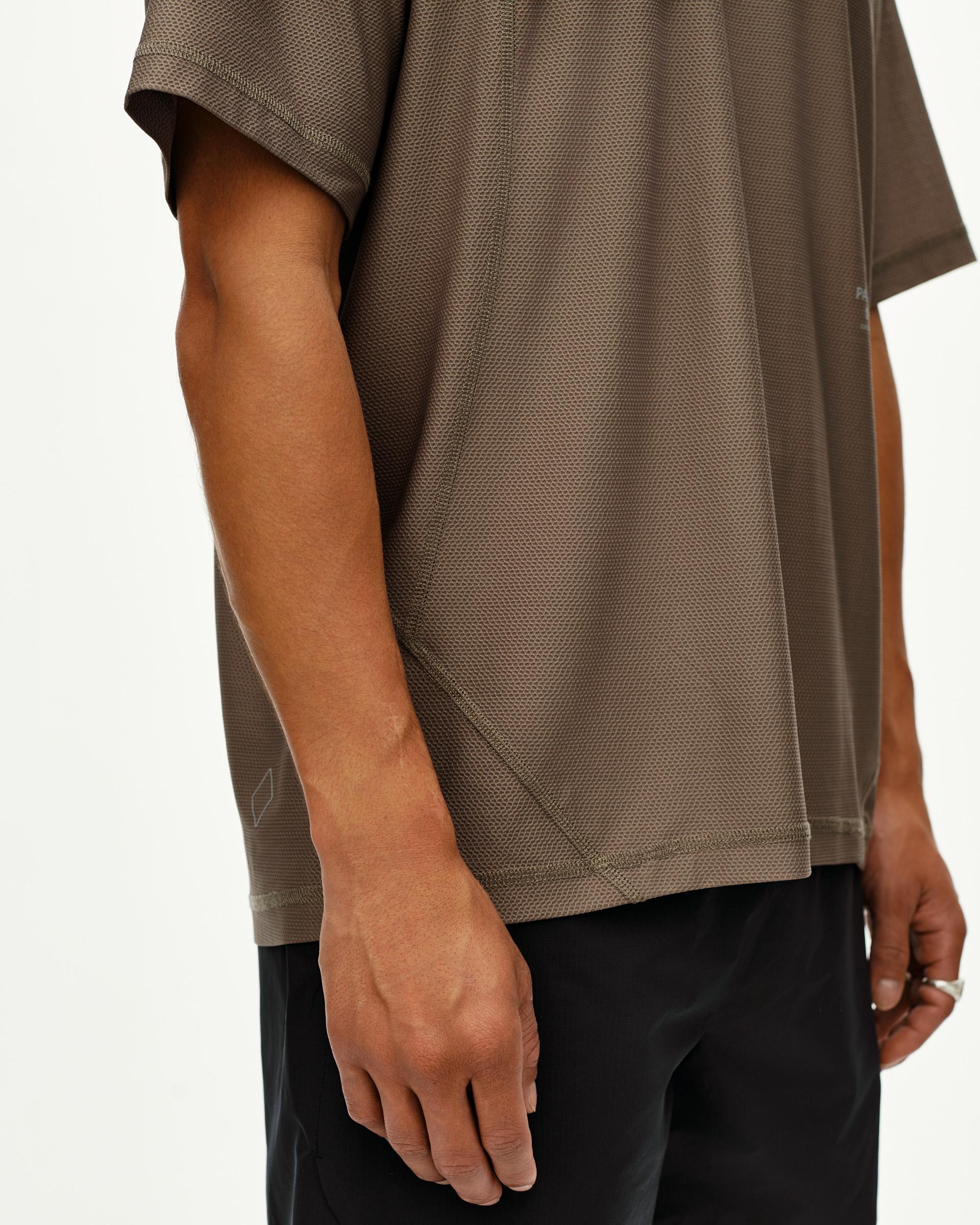 Stone Brown Balance T-shirt on model, side detail view with textured mesh fabric and tonal seam stitching