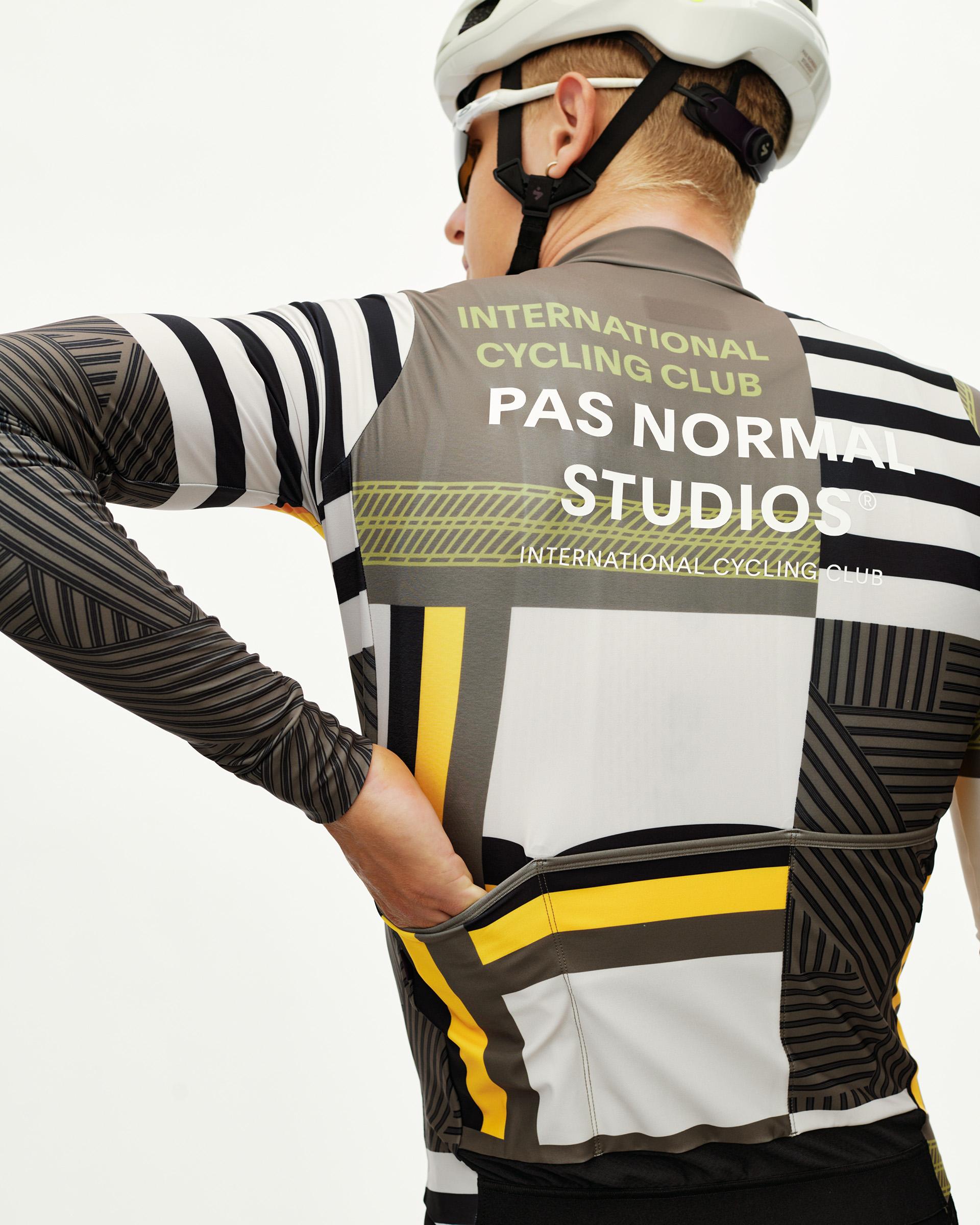 International Sand Mechanism long sleeve cycling jersey on model, rear view with geometric block print and yellow stripe