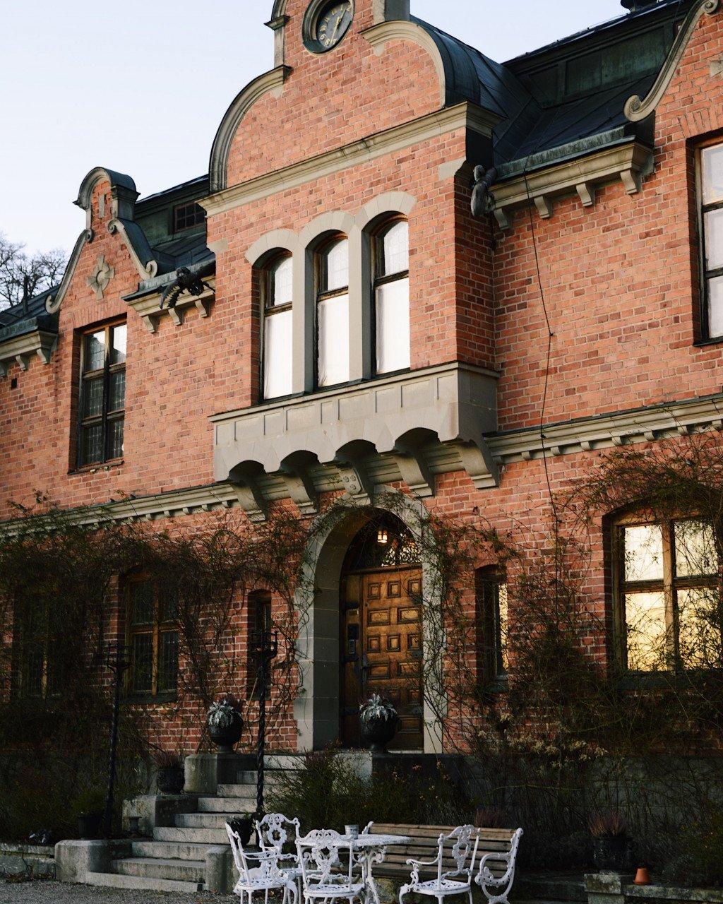 Historic red brick building with ornate architecture and outdoor seating area