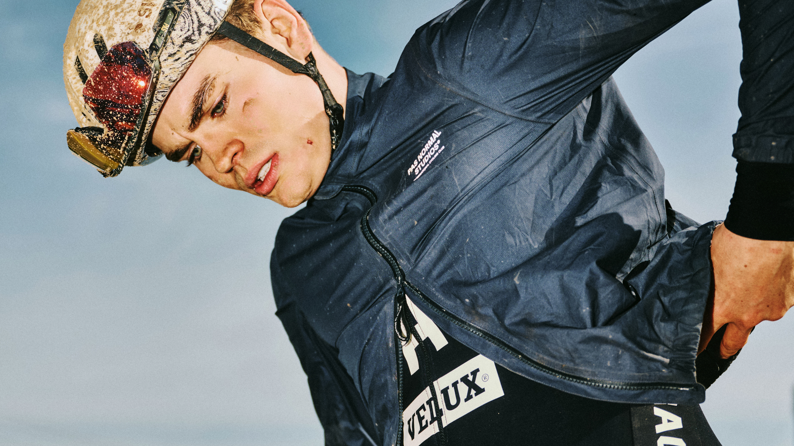 Model wearing navy IONITY x PAS Racing jacket with white branding and matching cycling cap