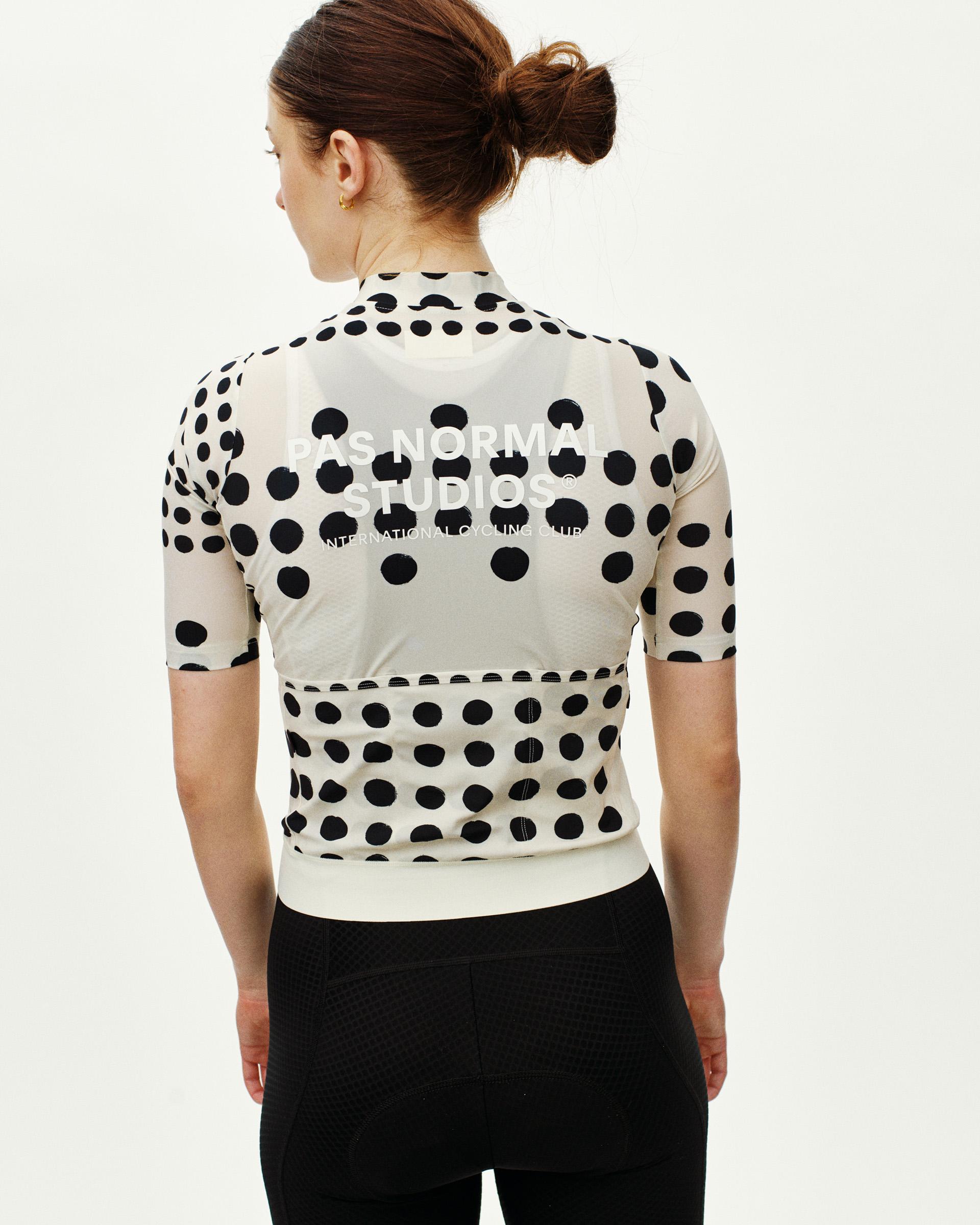 Off White Essential women's cycling jersey, rear view on model with black polka dot print and white logo