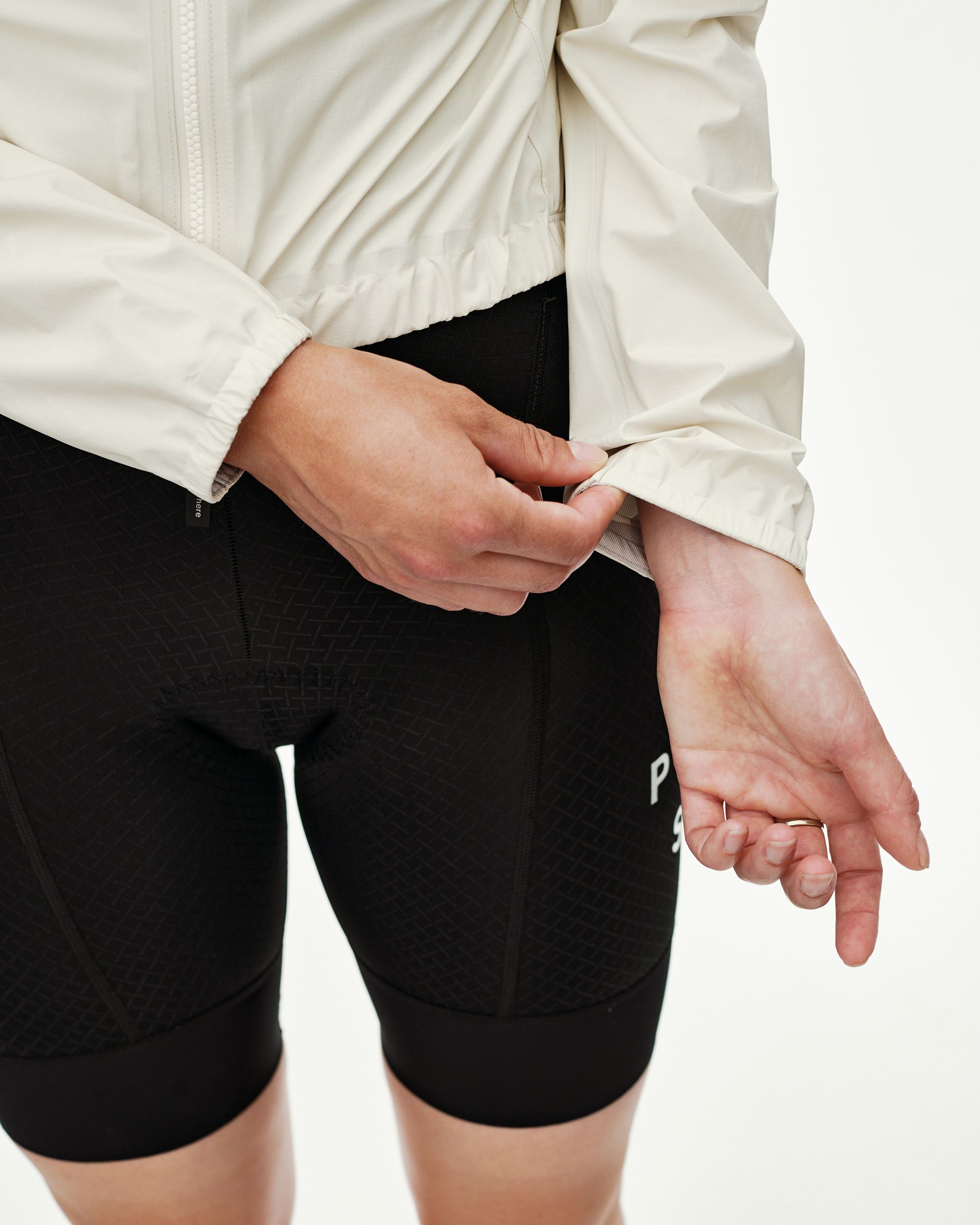 Off White Mechanism women's cycling rain jacket, side detail on model showing elastic cuff adjustment