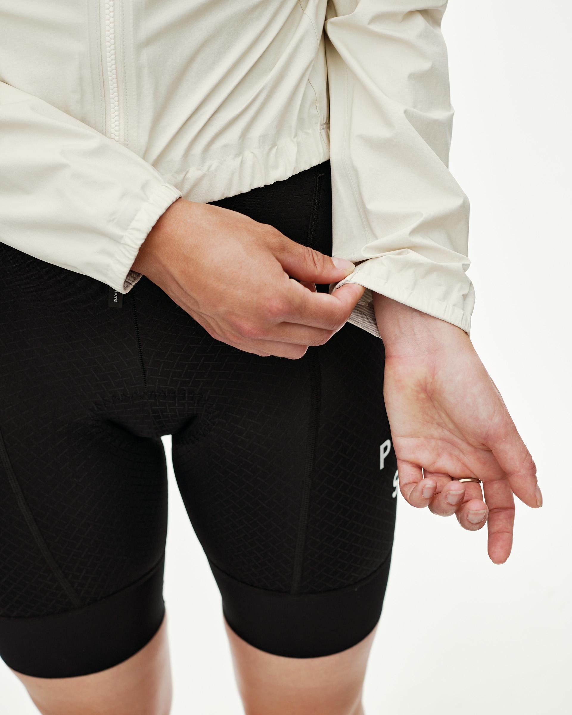 Off White Mechanism women's cycling rain jacket, side detail on model showing elastic cuff adjustment