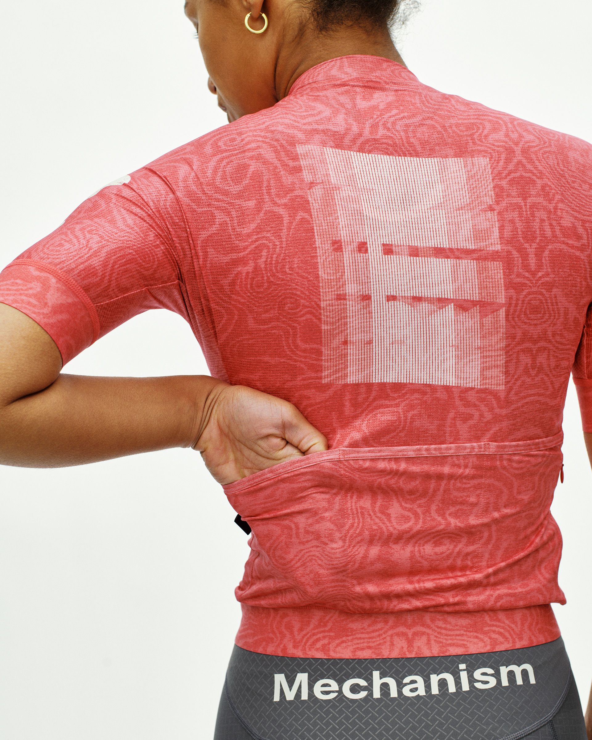 Red Mechanism cycling jersey on model, rear view with tonal all-over print and mesh back panel