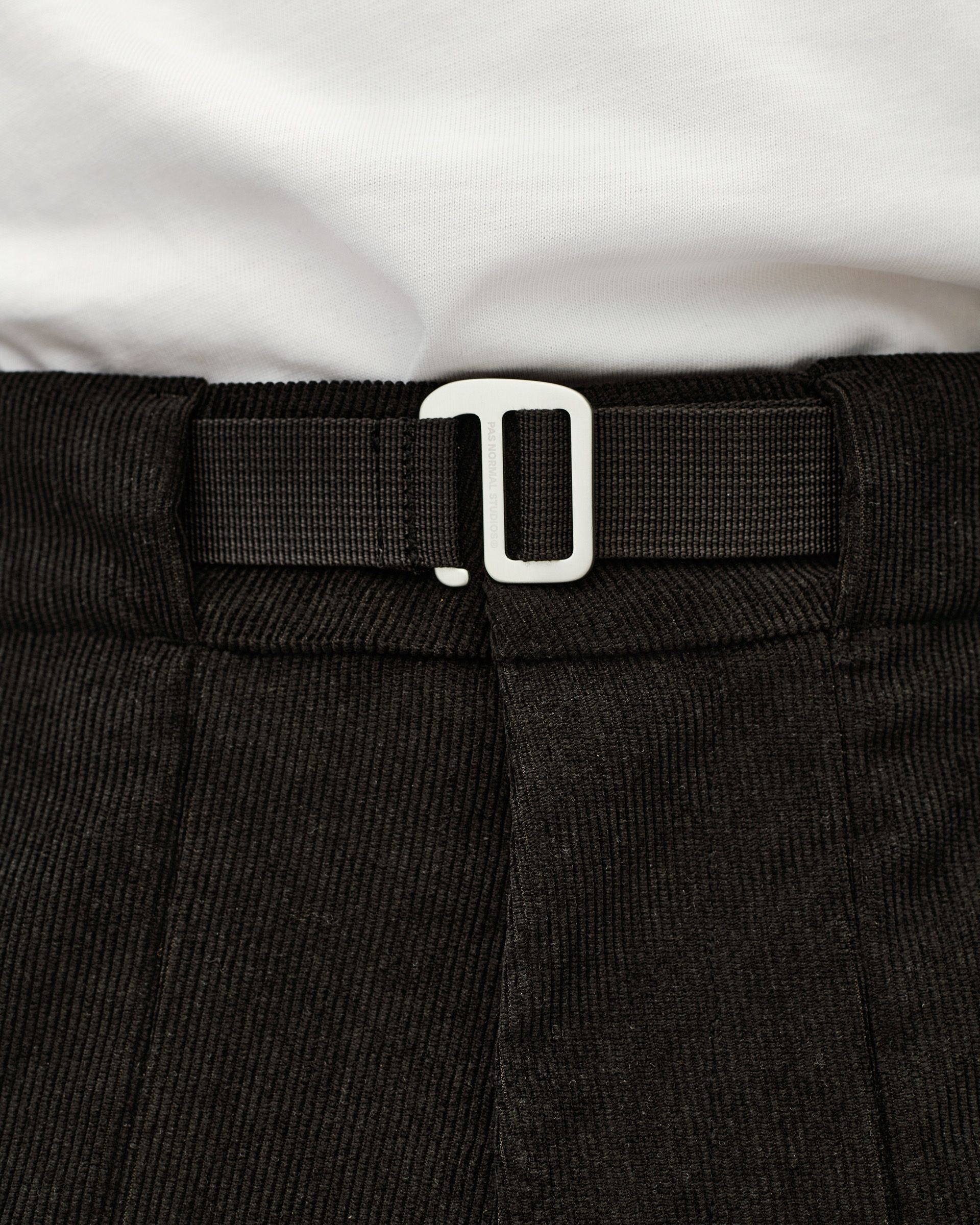 Black Off-Race Corduroy pants, detail view of white buckle clasp on webbing waistband