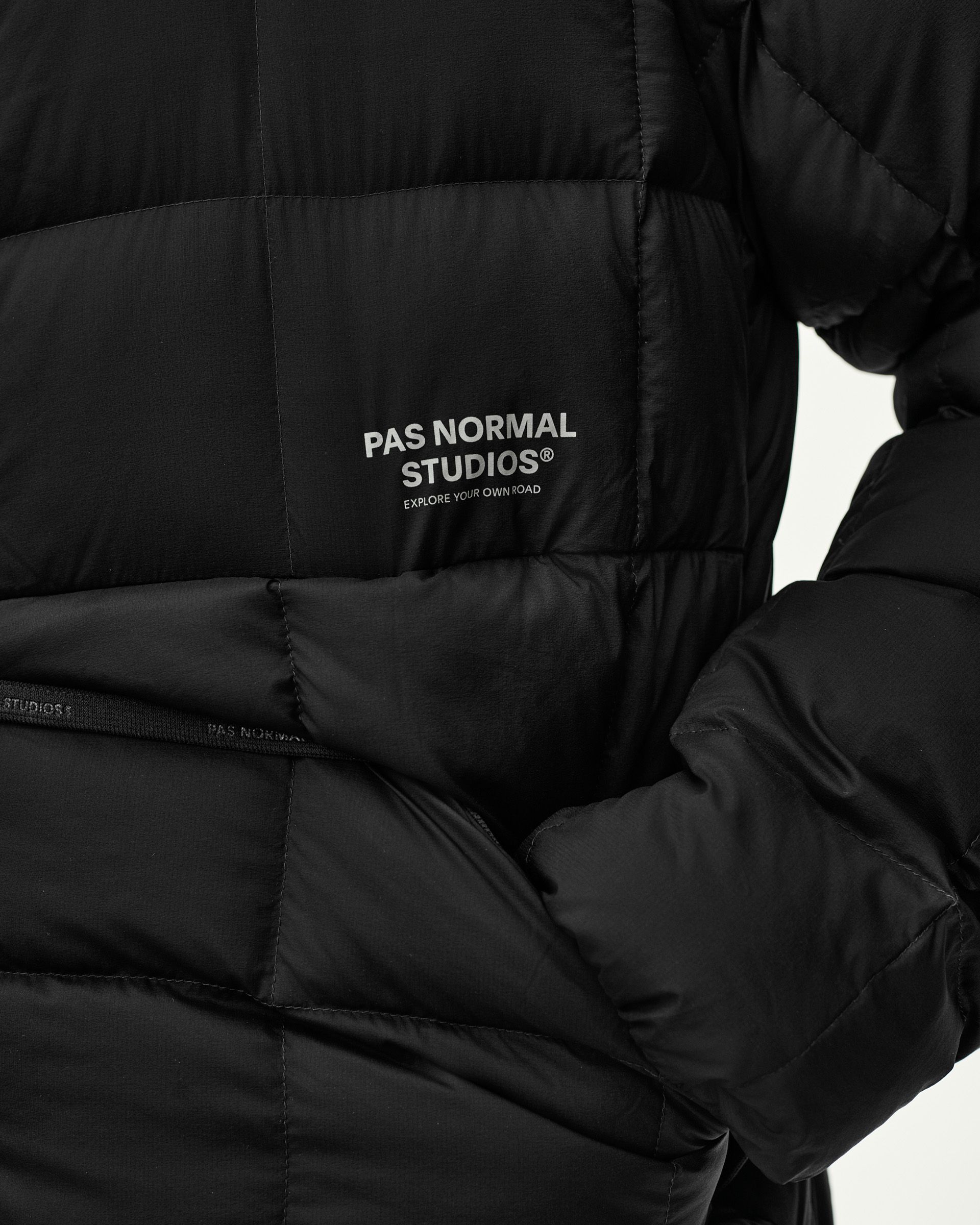 Black Off-Race Down Liner jacket, detail view of quilted chest with grey logo print and side zip pocket