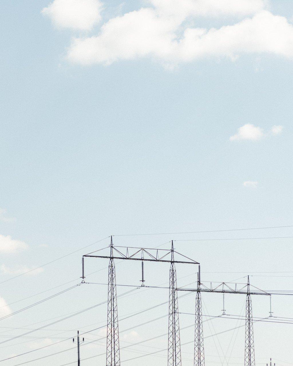 Power transmission towers and lines against cloudy sky
