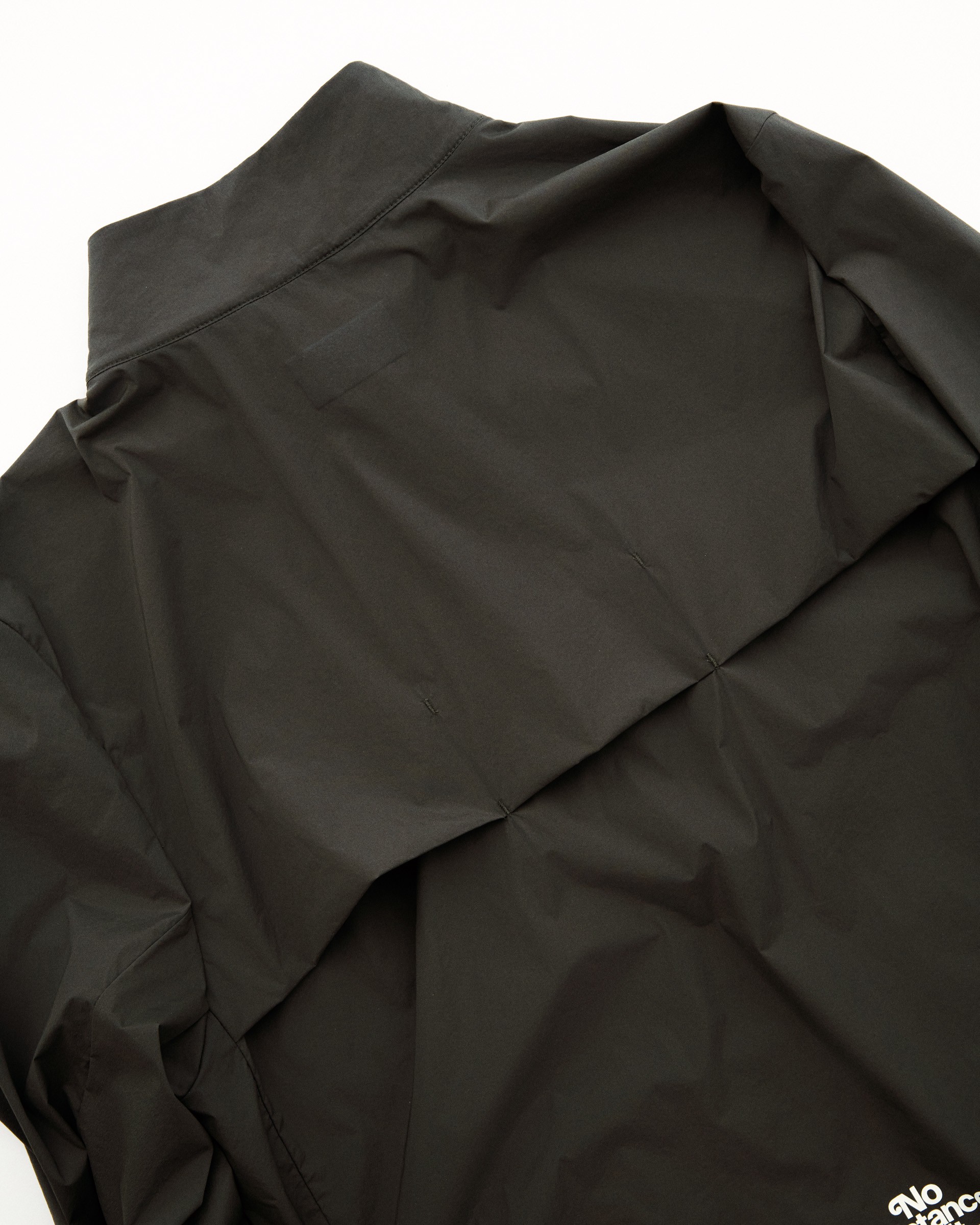 Back panel ventilation opening on dark jacket for airflow and moisture management