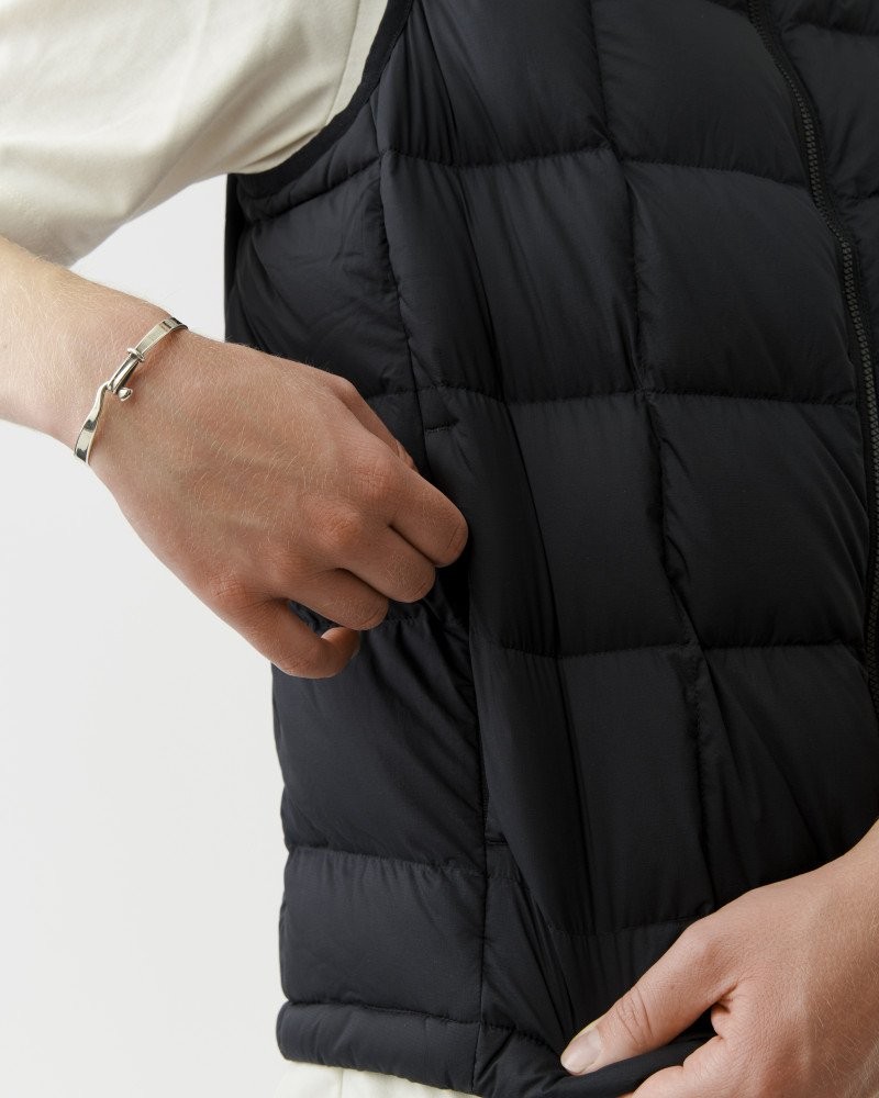 Black Off-Race Down Vest, side detail on model showing quilted panels and zip side pocket