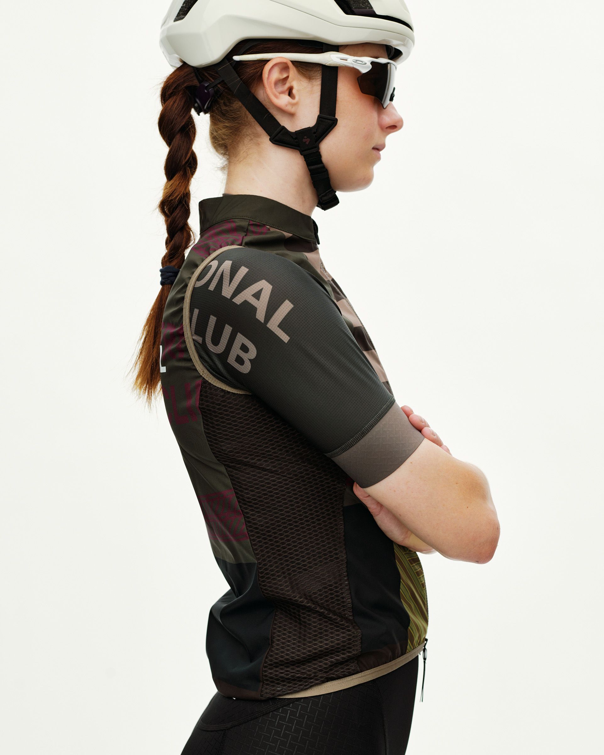 Dusty Earth khaki Mechanism Stow Away women's cycling gilet, side view on model with graphic sleeve print